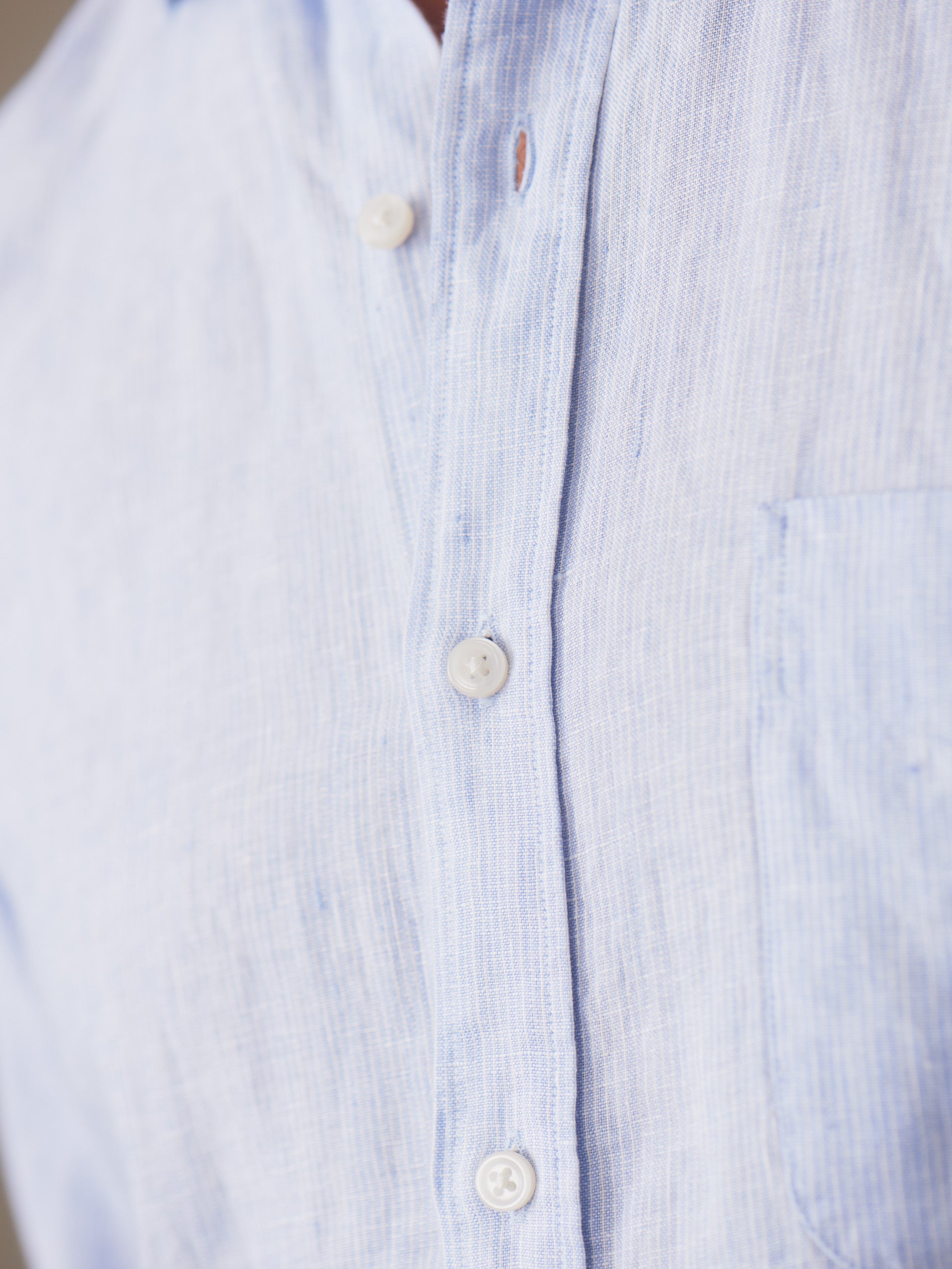 Close-up of the Gramercy Linen Shirt in Hairline Stripe by J.McLaughlin, showcasing its finely crafted blue and white striped linen fabric, reflecting effortlessly stylish, enduring designs and a legacy of timeless fashion at a destination for defining style. Life, Well-Lived.
