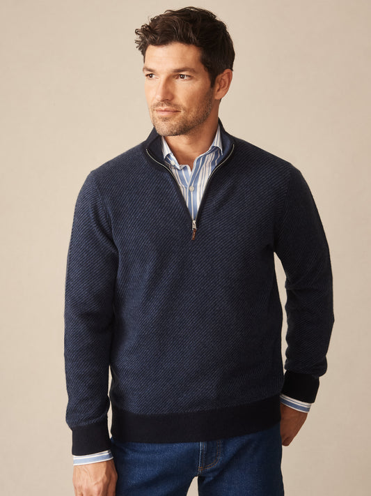 Man wearing a navy textured sweater layered over a striped button-down shirt, showcasing the Twain Cashmere 1/4 Zip in Jacquard by J.McLaughlin, effortlessly stylish with enduring designs.