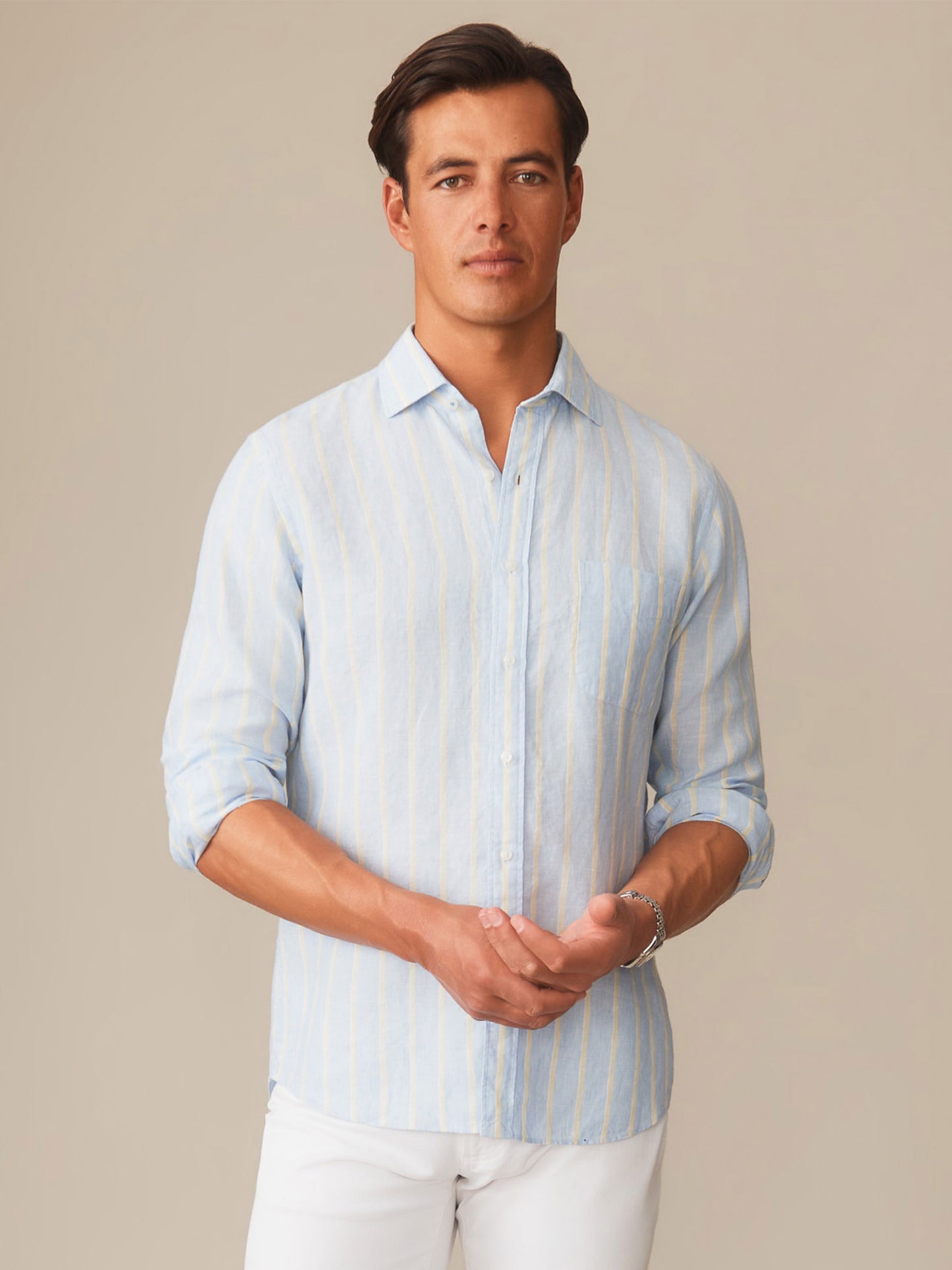 A man wearing a Gramercy Linen Shirt in Dobby Stripe by J.McLaughlin, featuring effortlessly stylish design and innovative fabrics for enduring appeal in timeless fashion.