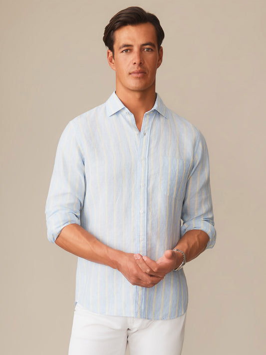 A man wearing a Gramercy Linen Shirt in Dobby Stripe by J.McLaughlin, featuring effortlessly stylish design and innovative fabrics for enduring appeal in timeless fashion.