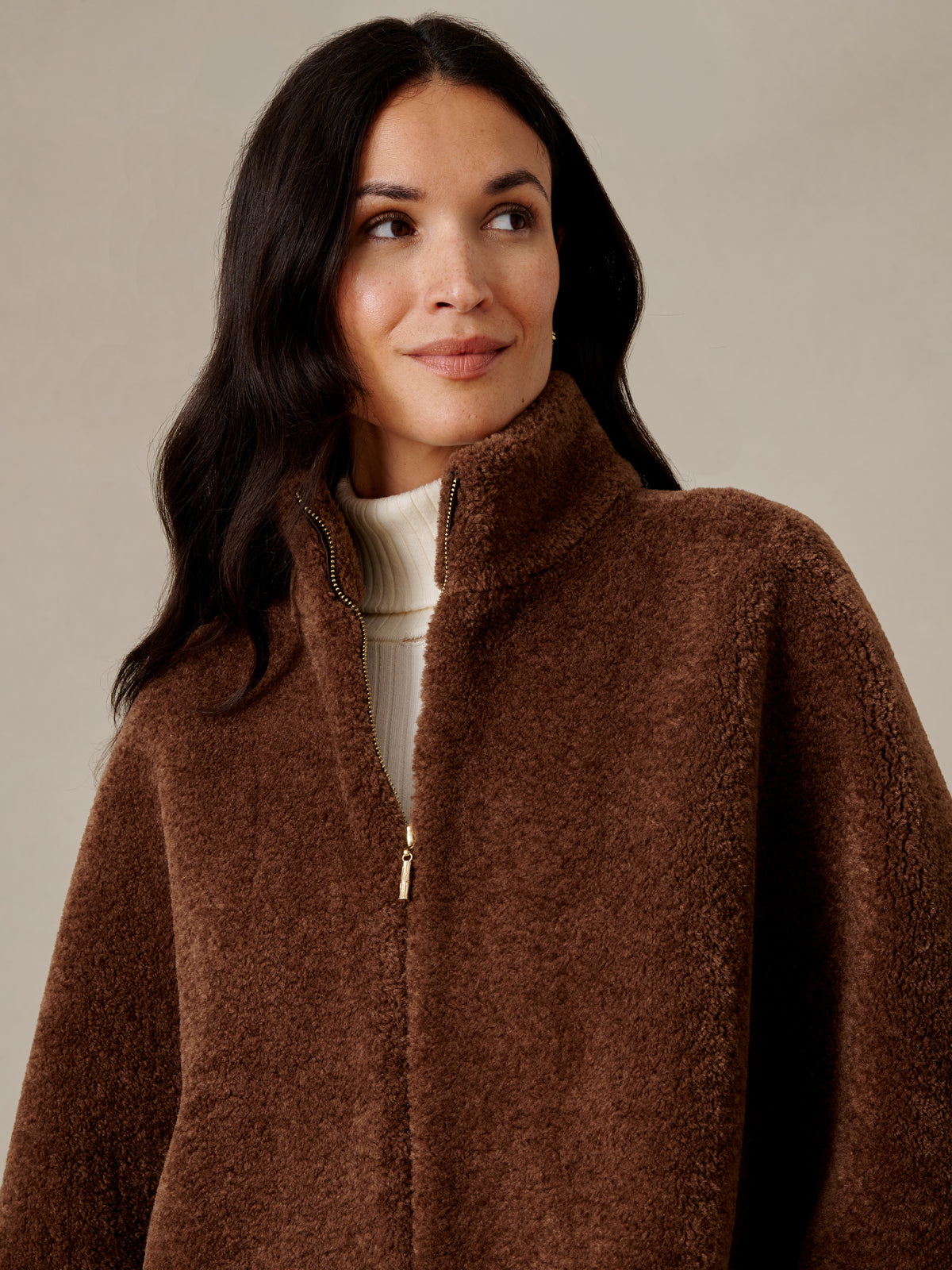 Gretchen Faux Fur Cape by J.McLaughlin in rich brown plush faux fur with a high collar and gold tone bamboo inspired zipper worn by a woman