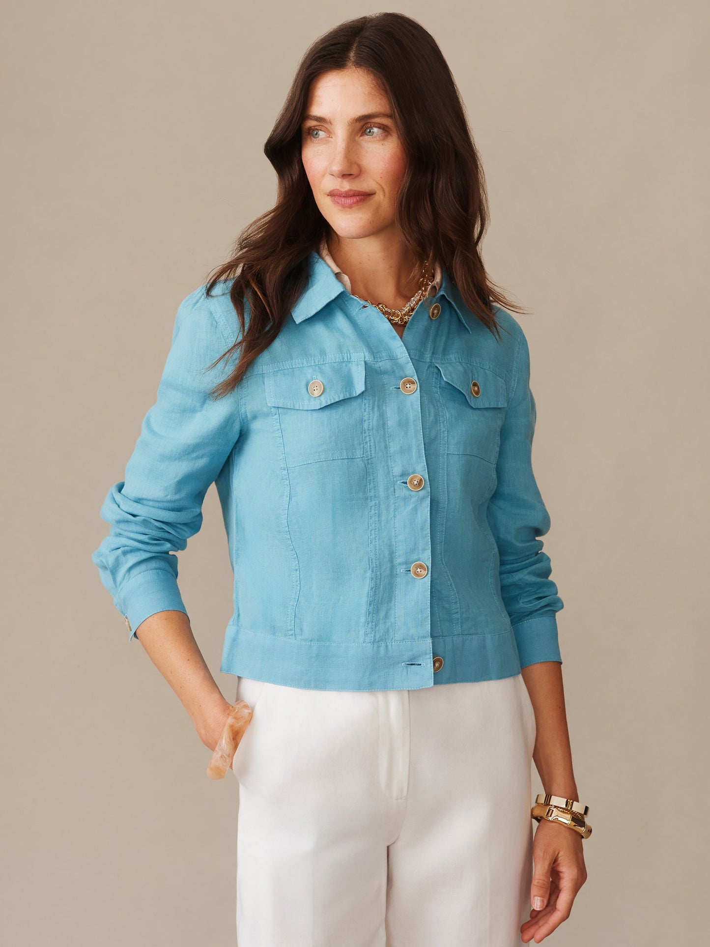 Woman wearing a teal Halo Linen Jacket by J.McLaughlin paired with white pants, showcasing effortlessly stylish and enduring designs made from innovative fabrics, embodying a legacy of timeless fashion. A destination for defining style. Life, Well-Lived.