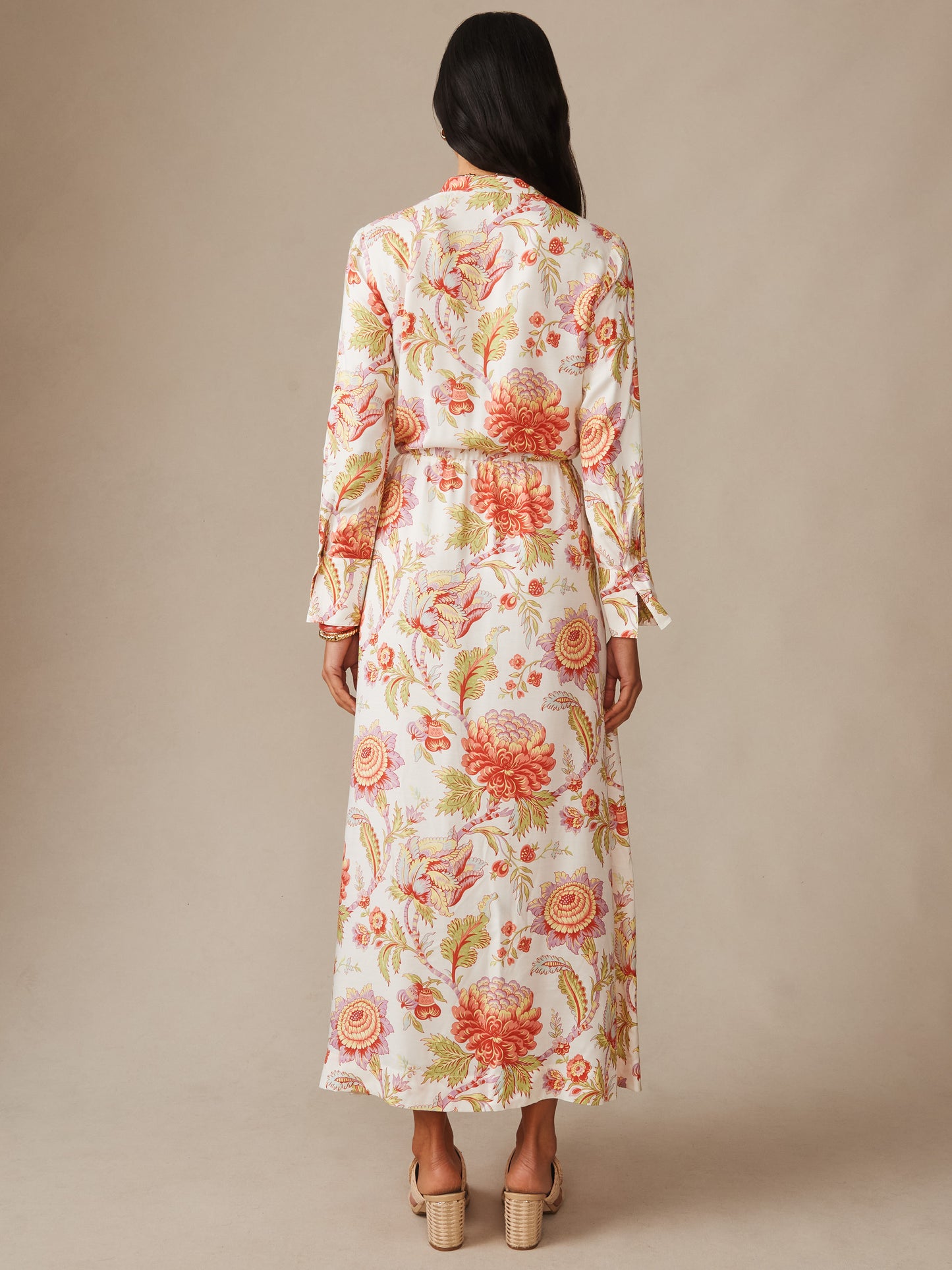 Model seen from behind wearing the Hannah Silk Blend Dress in Cerulean Garden by J.McLaughlin, featuring a floral pattern in warm tones on a soft off-white background, embodying effortlessly stylish, enduring designs with innovative fabrics and a legacy of timeless fashion for a destination defining style, life well-lived.
