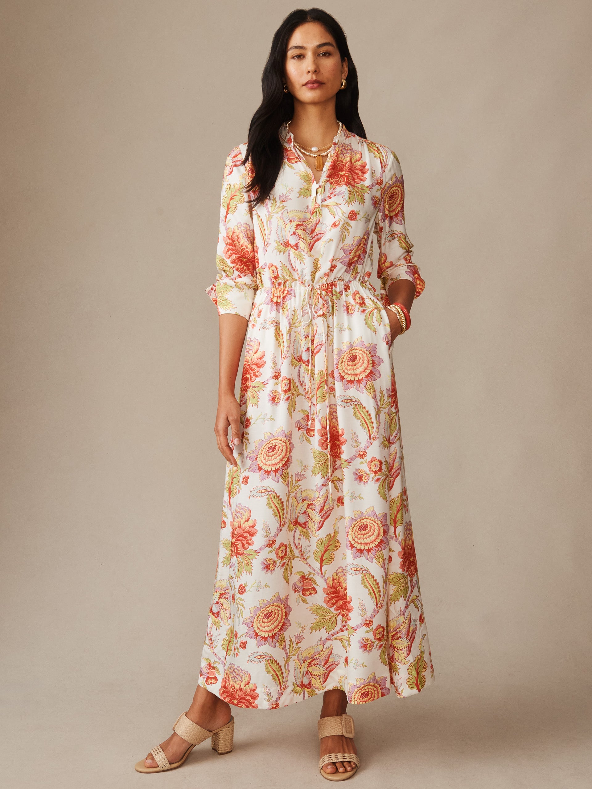 Woman wearing a Hannah Silk Blend Dress in Cerulean Garden by J.McLaughlin, featuring a floral pattern in warm tones, styled with simple jewelry and neutral sandals, embodying effortlessly stylish, enduring designs with innovative fabrics for a legacy of timeless fashion. A destination for defining style. Life, Well-Lived.