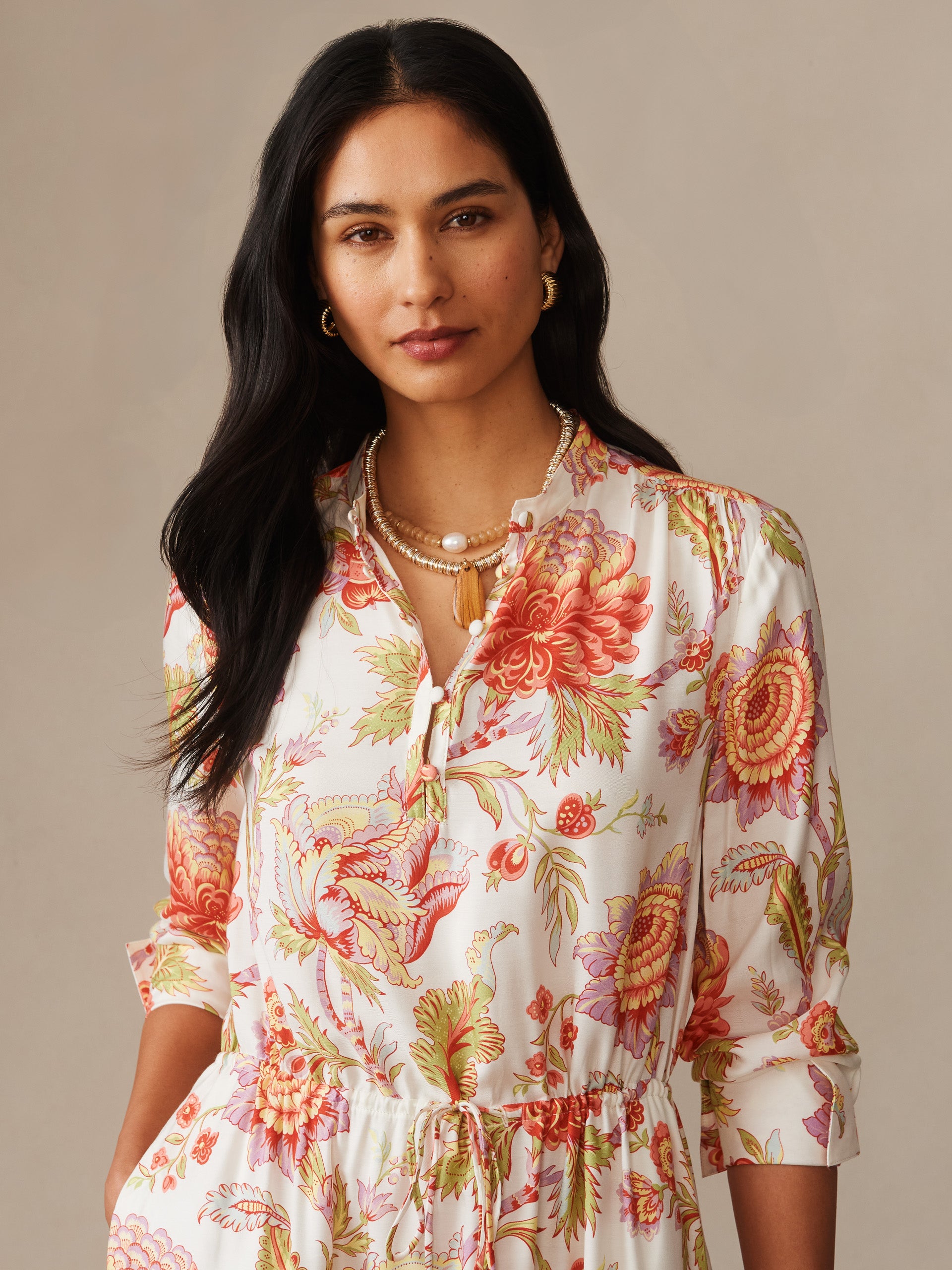 A close-up of a woman wearing the Hannah Silk Blend Dress in Cerulean Garden by J.McLaughlin, featuring a vibrant floral pattern and delicate craftsmanship, reflecting effortless style and enduring design in innovative fabrics. A destination for defining style. Life, Well-Lived.