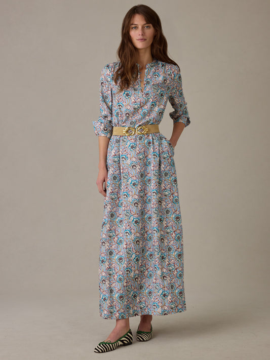 Woman wearing a Hannah Silk Blend Dress in Belle Epoque Bloom by J.McLaughlin, featuring a floral pattern, long sleeves, and a stylish belt, paired with striped flats.