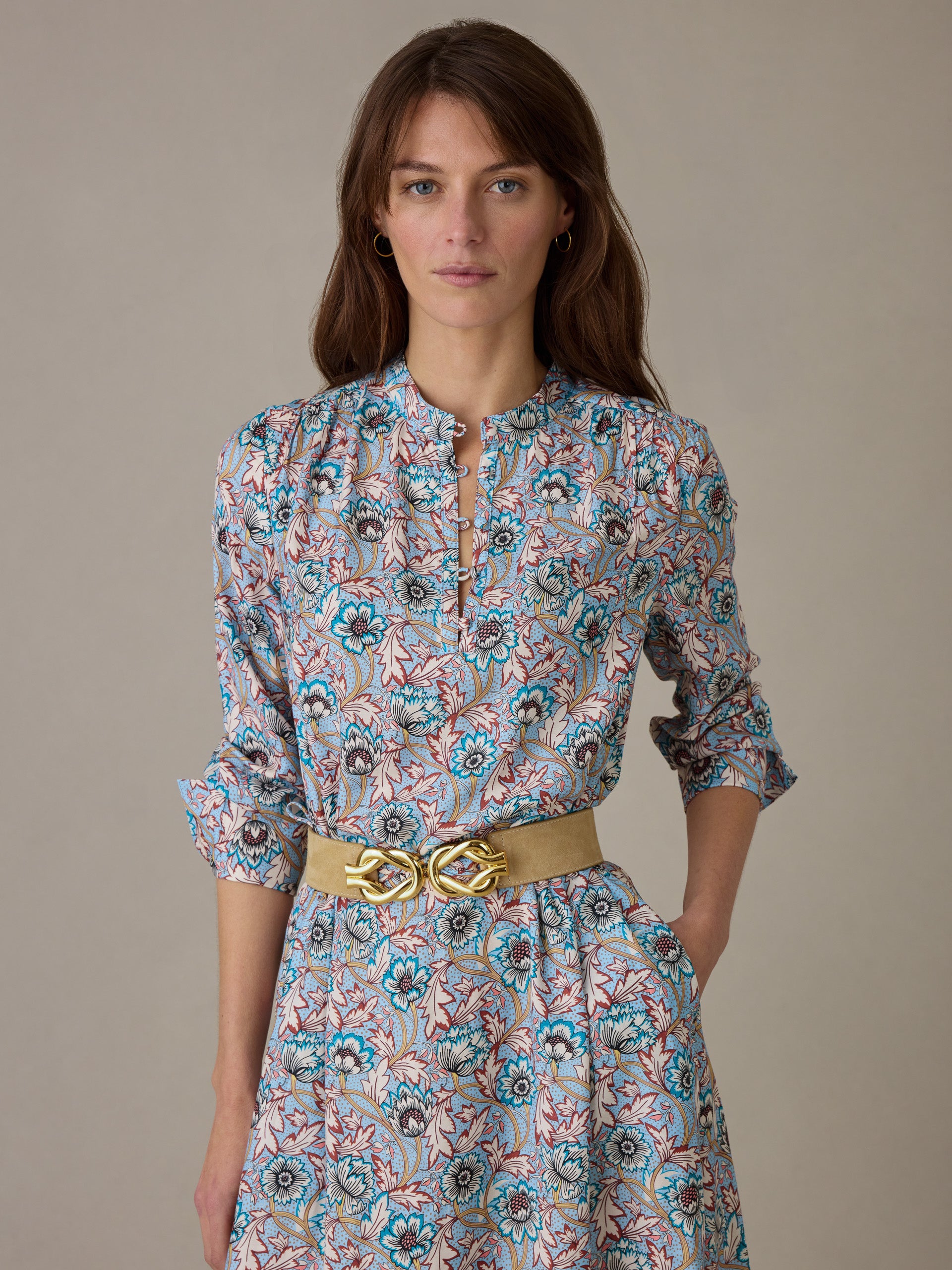 Woman modeling the Hannah Silk Blend Dress in Belle Epoque Bloom by J.McLaughlin, featuring a floral pattern with rolled sleeves and a beige belt, embodying timeless style.