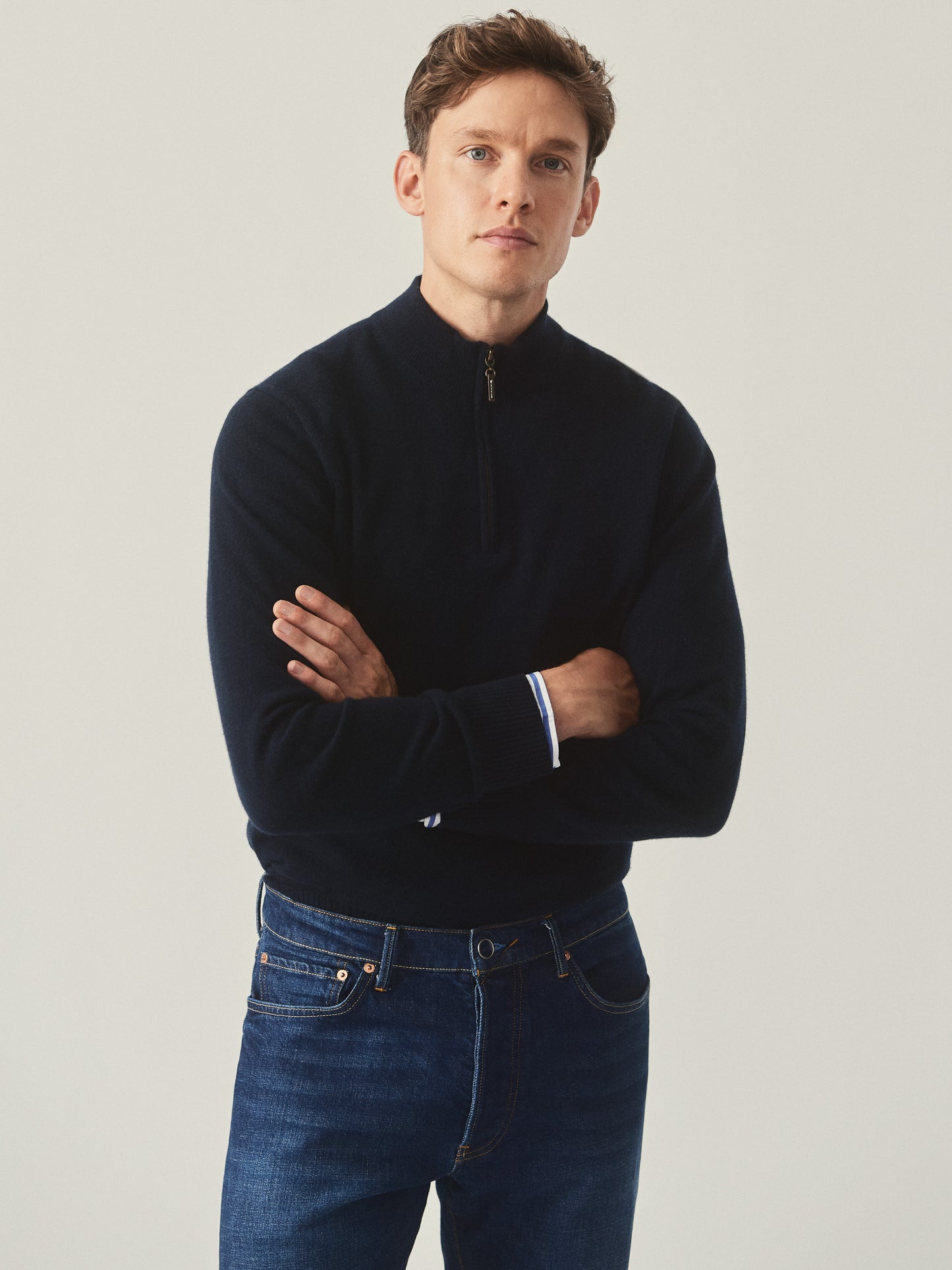 Model wearing J.McLaughlin Henry sweater in dark olive made with cashmere.