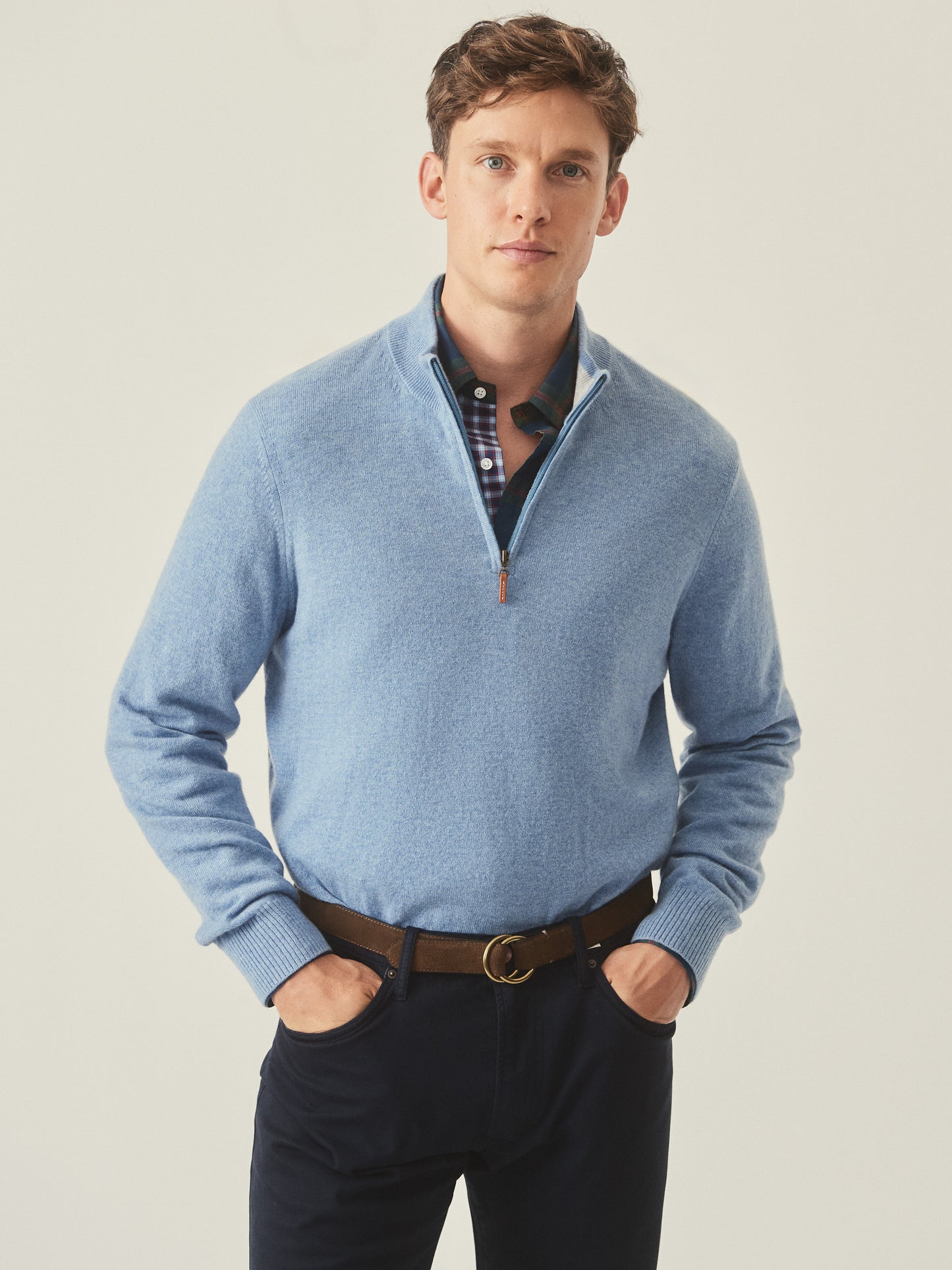 Model wearing J.McLaughlin Henry 1/4 zip in washed denim made with cashmere.