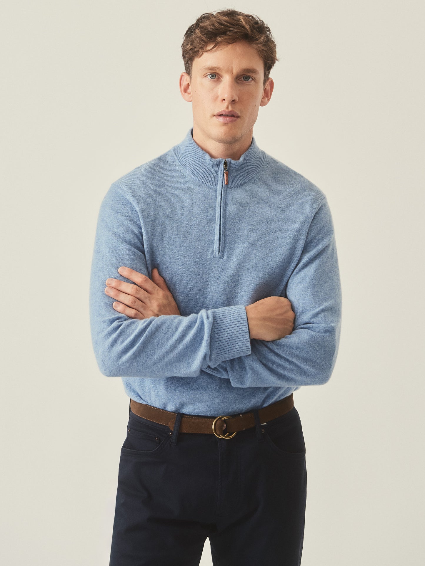 Model wearing J.McLaughlin Henry 1/4 zip in washed denim made with cashmere.