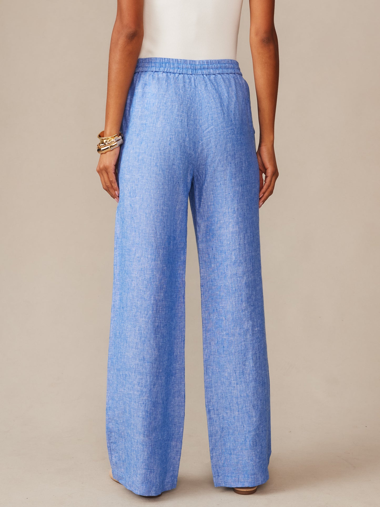 Back view of a person wearing light blue Irene Linen Pants by J.McLaughlin, showcasing effortlessly stylish, enduring designs crafted with innovative fabrics for a legacy of timeless fashion.