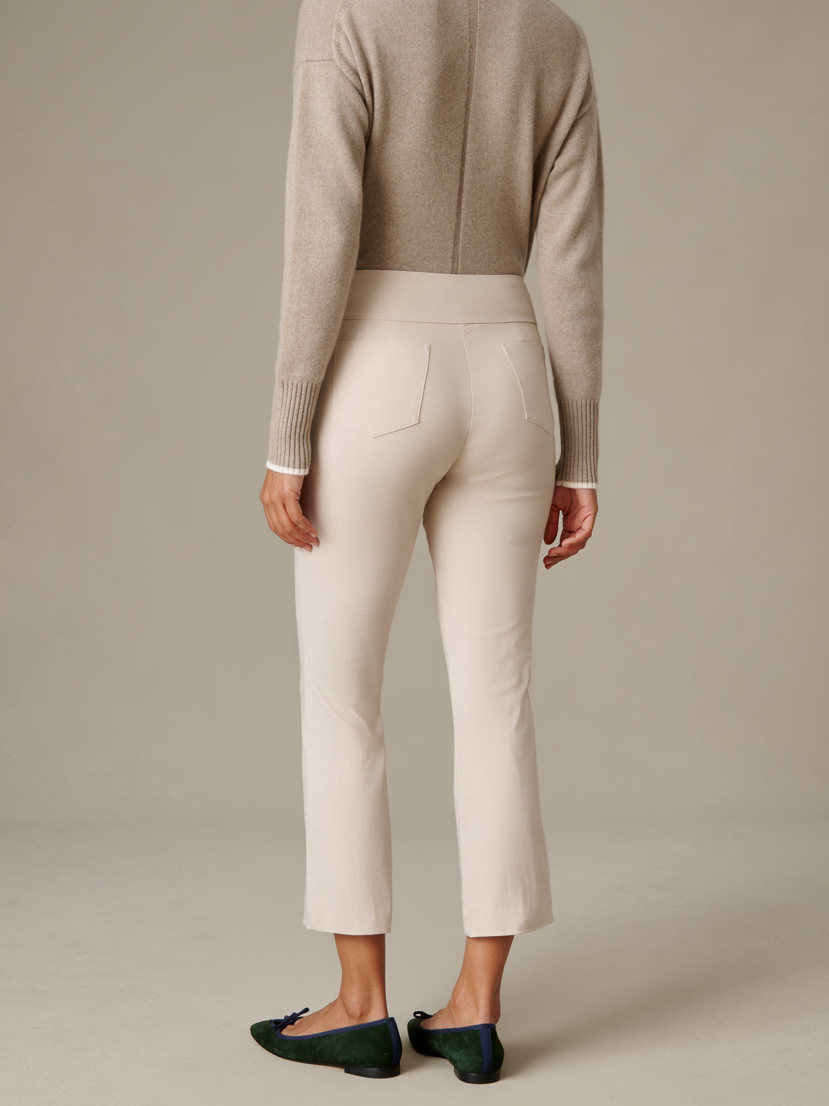 J.McLaughlin Ivy Pants in ivory shown from the back with a clean pull on fit and subtle flare leg styled with a taupe sweater and green flats