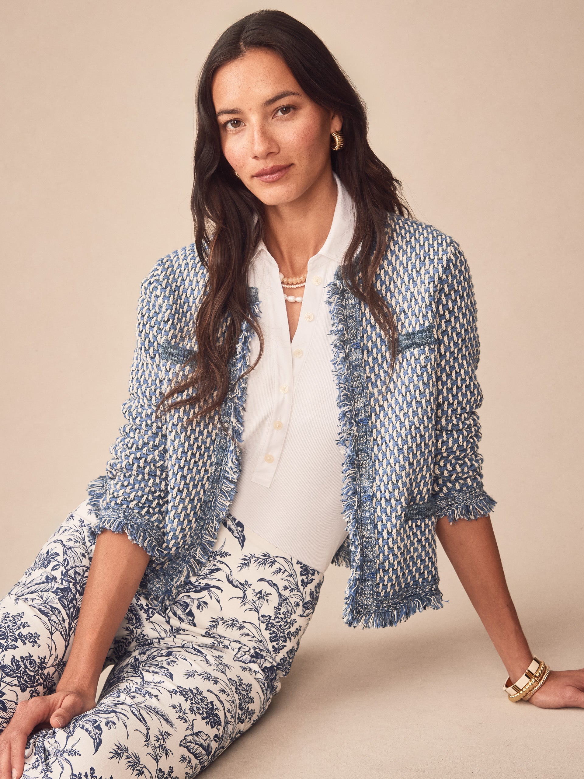 Woman wearing a blue and white textured Marceline Cardigan by J.McLaughlin over a white blouse with patterned pants, showcasing effortlessly stylish and enduring designs for life well-lived.