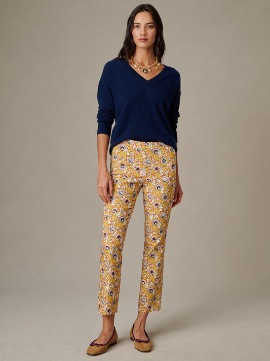 Woman wearing J.McLaughlin Ivy Pants in Belle Epoque Bloom with a navy V-neck sweater and brown flats, showcasing effortlessly stylish and enduring designs.