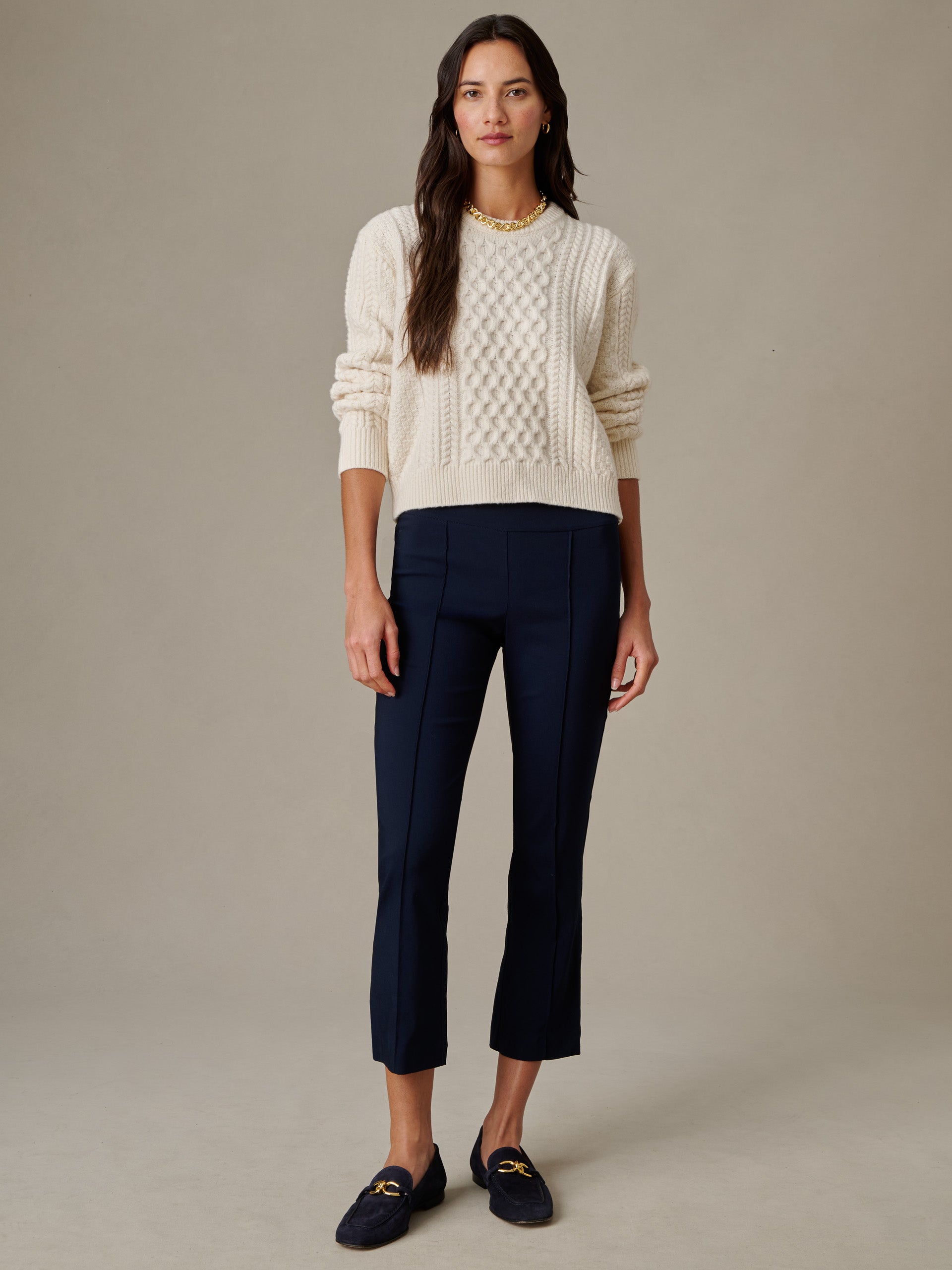 Woman wearing navy Ivy Pants by J.McLaughlin paired with a cream textured sweater and loafers, showcasing effortlessly stylish, enduring design with impeccable craftsmanship.