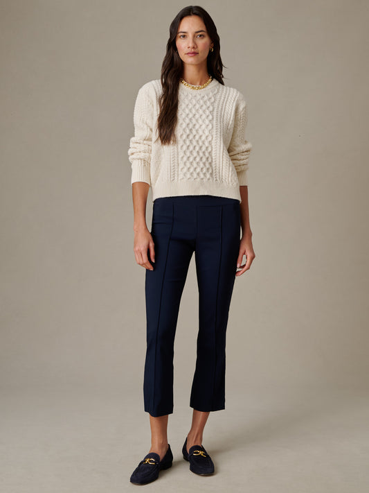 Woman wearing navy Ivy Pants by J.McLaughlin paired with a cream textured sweater and loafers, showcasing effortlessly stylish, enduring design with impeccable craftsmanship.