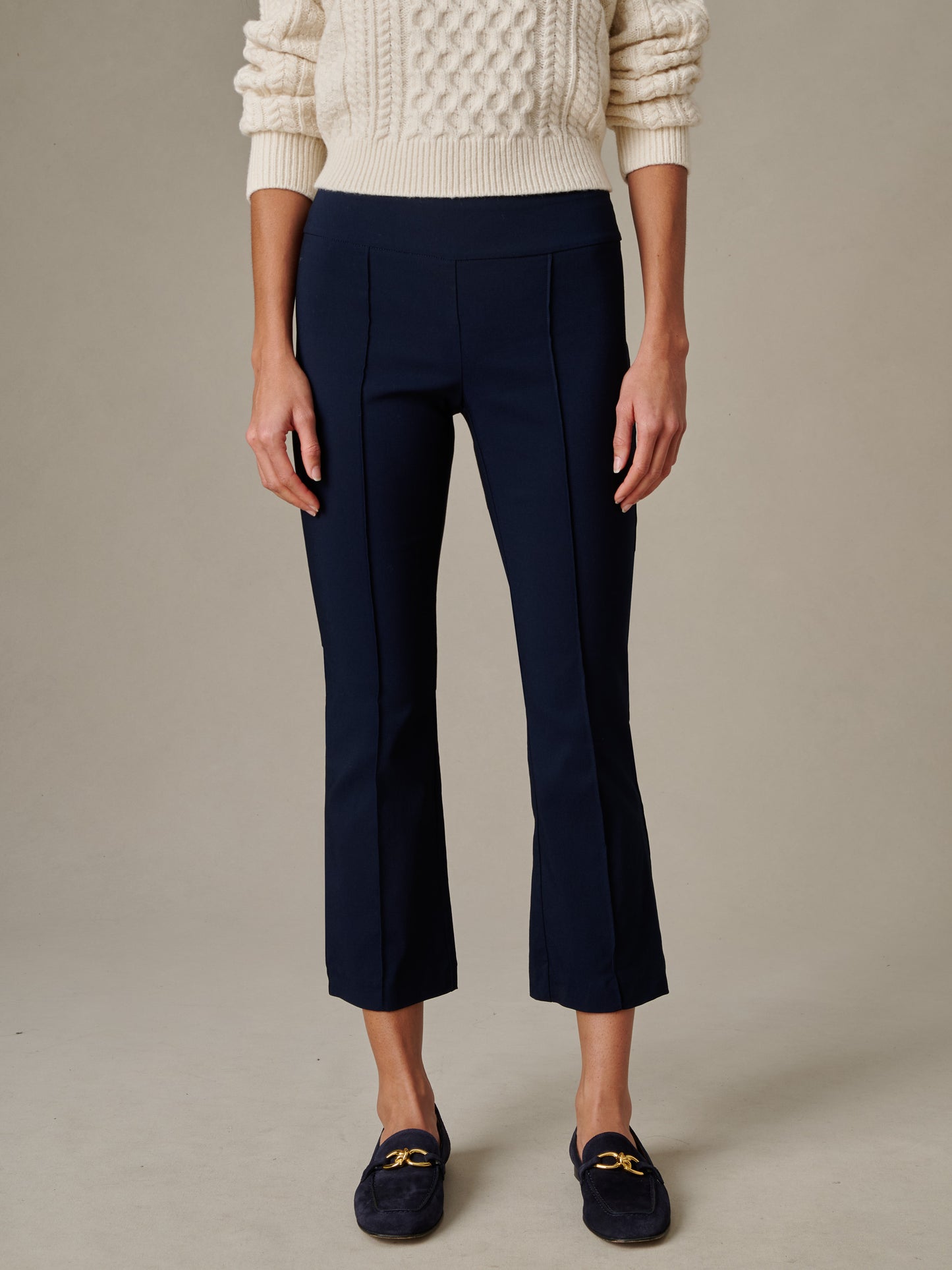 Woman wearing navy Ivy Pants by J.McLaughlin paired with a cream cable knit sweater and navy loafers, showcasing an effortlessly stylish and timeless look.
