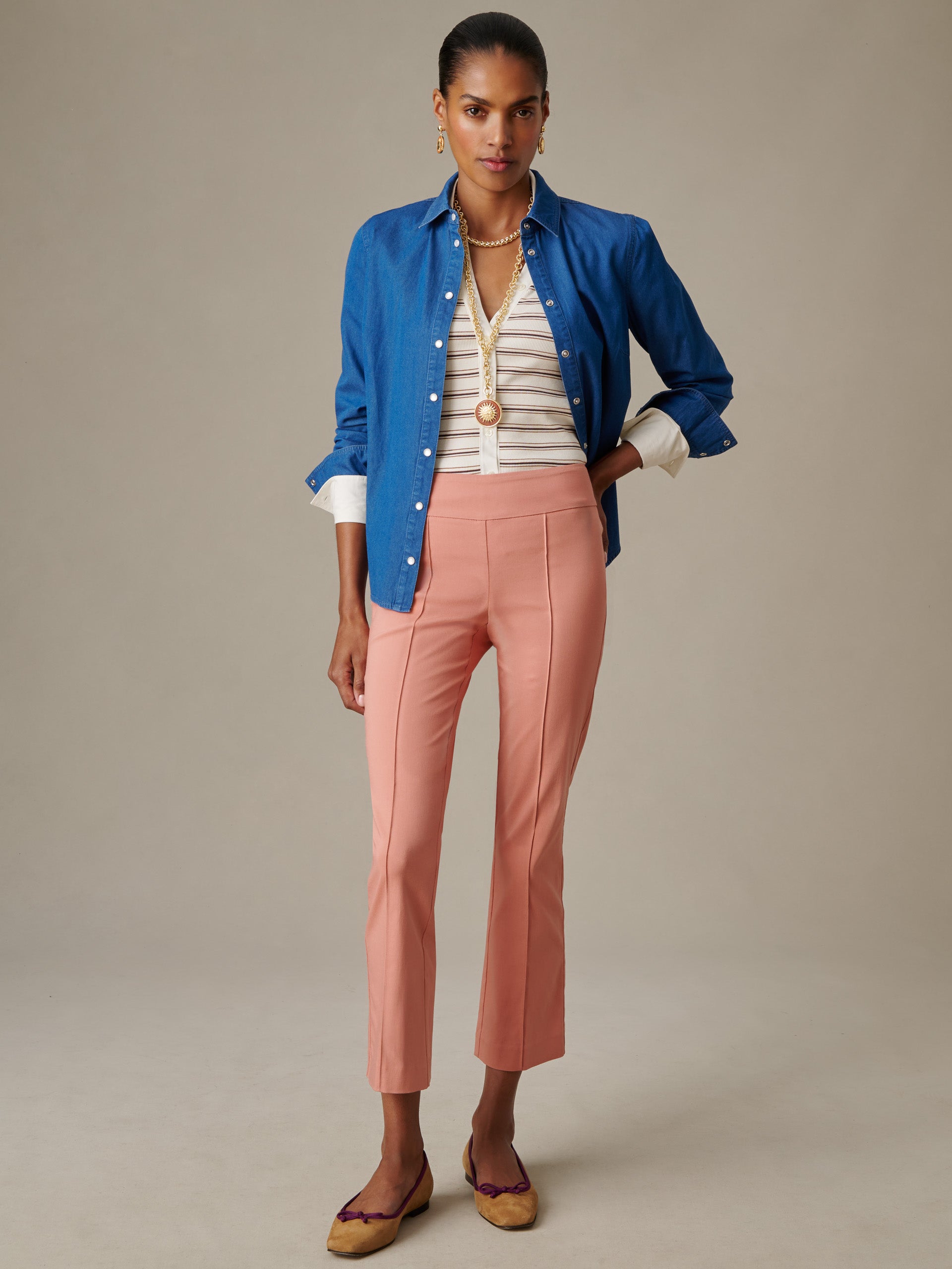 Woman wearing pink Ivy Pants by J.McLaughlin paired with a striped top and blue button-down shirt, showcasing a timeless, effortlessly stylish look for both women and men.