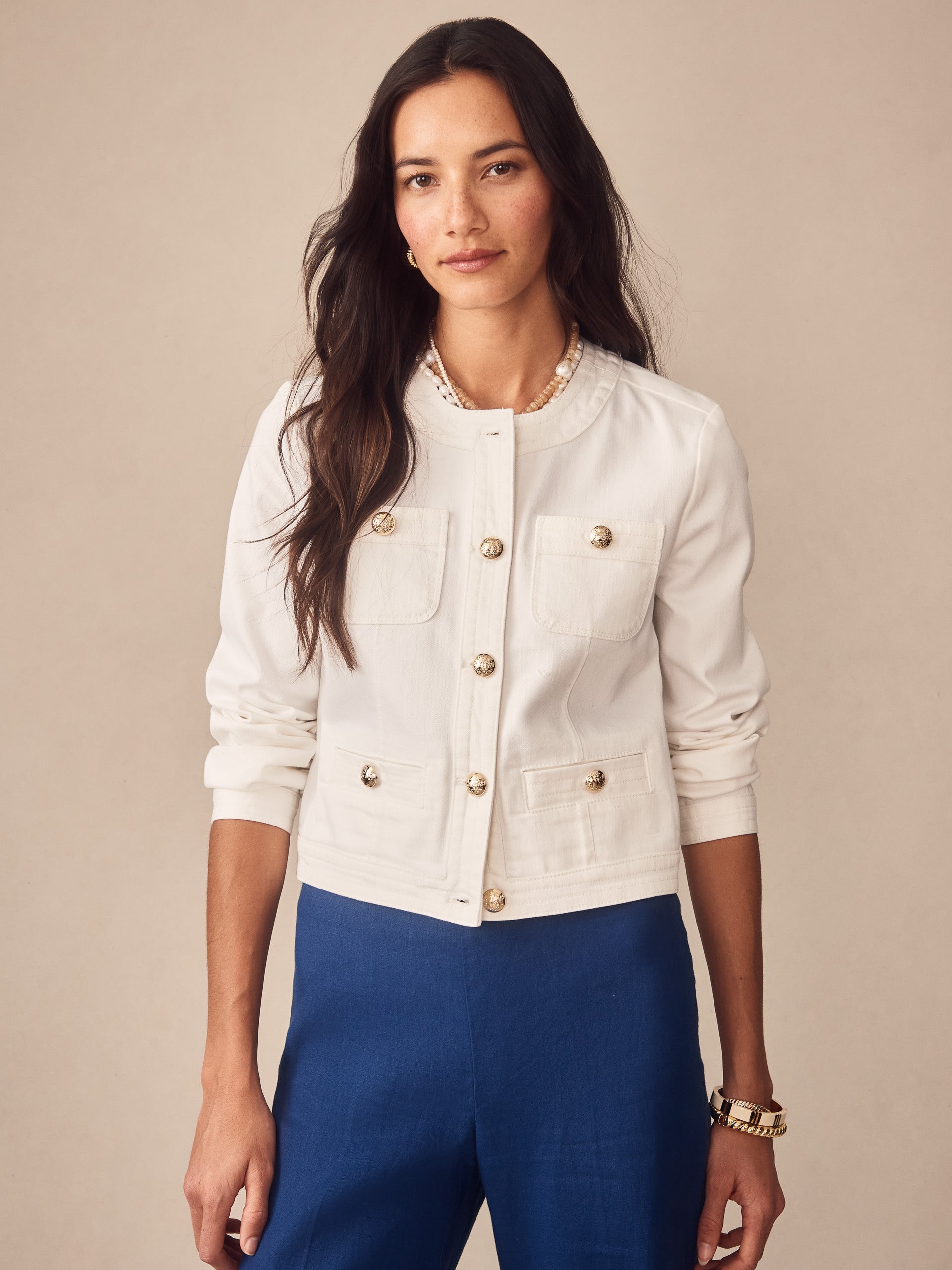 A woman models the Jackie Denim Jacket by J.McLaughlin in a crisp white fabric, showcasing effortlessly stylish, enduring designs crafted for timeless appeal and innovative fabrics.