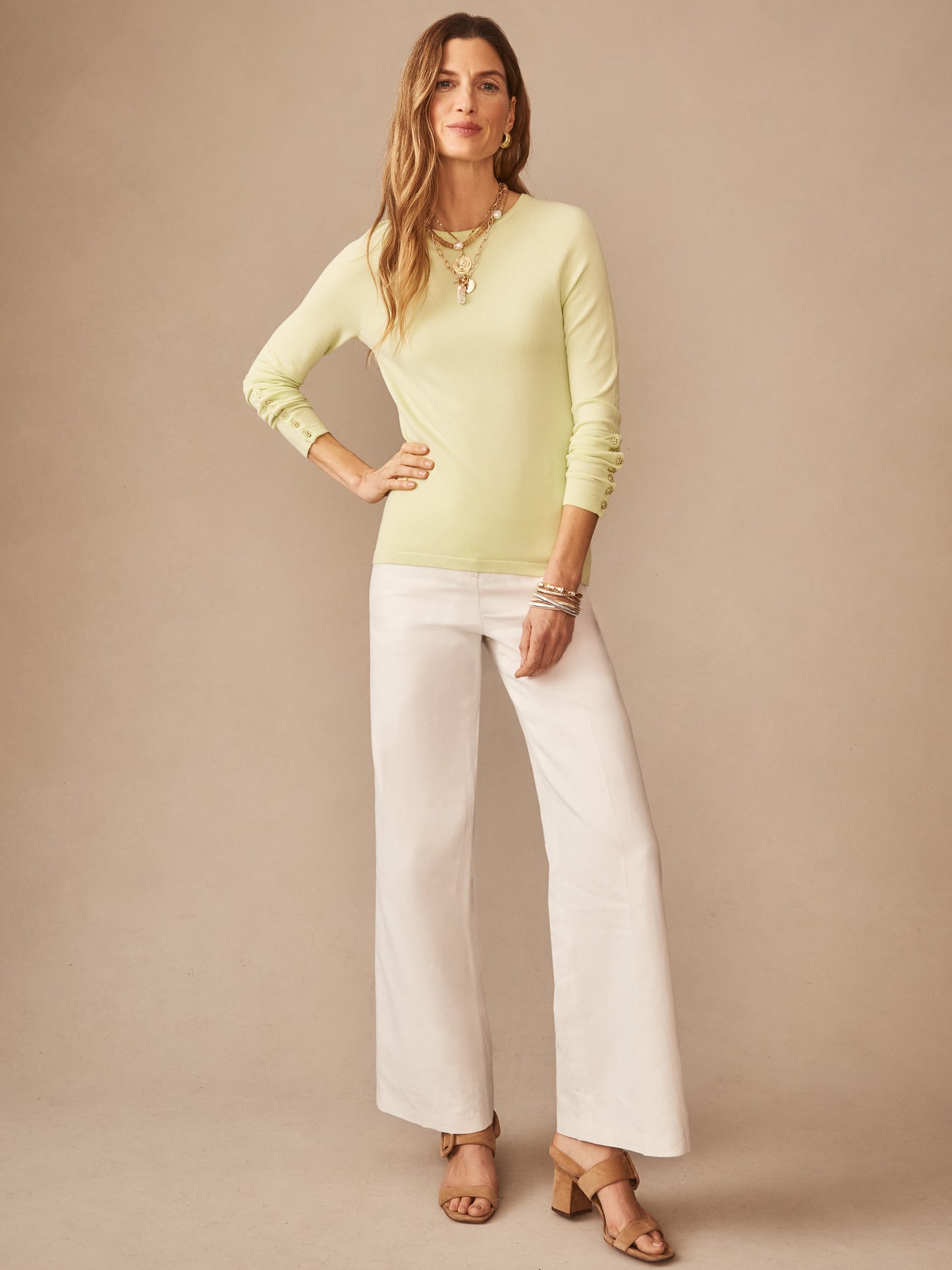 Woman wearing a lime green Jamey Sweater by J.McLaughlin paired with white wide-leg pants and tan sandals, showcasing effortlessly stylish, enduring designs and innovative fabrics in a legacy of timeless fashion. A destination for defining style. Life, Well-Lived.
