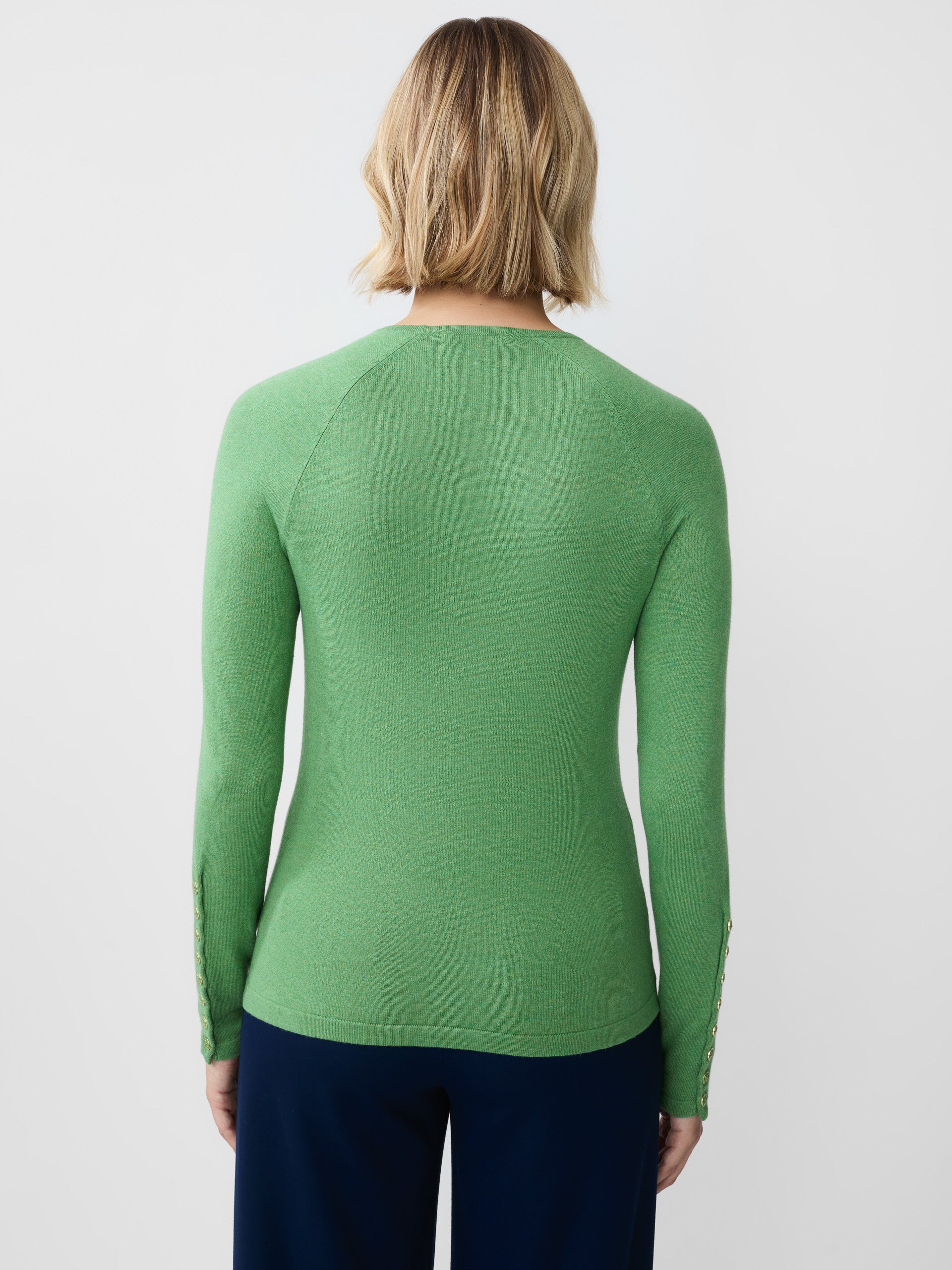 Model wearing J.McLaughlin Jamey sweater in light heather green made with cotton/modal.