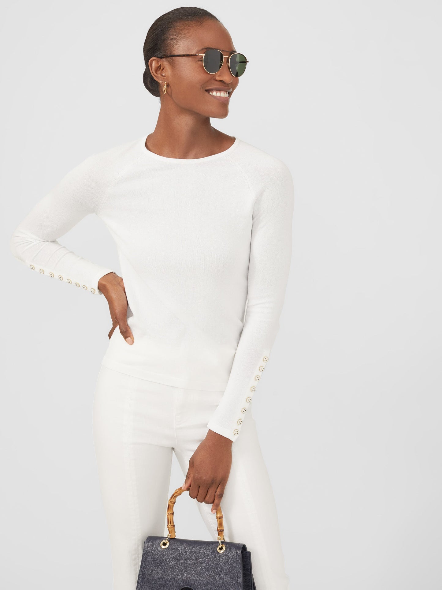 Model wearing J.McLaughlin Jamey sweater in white made with cotton/modal.