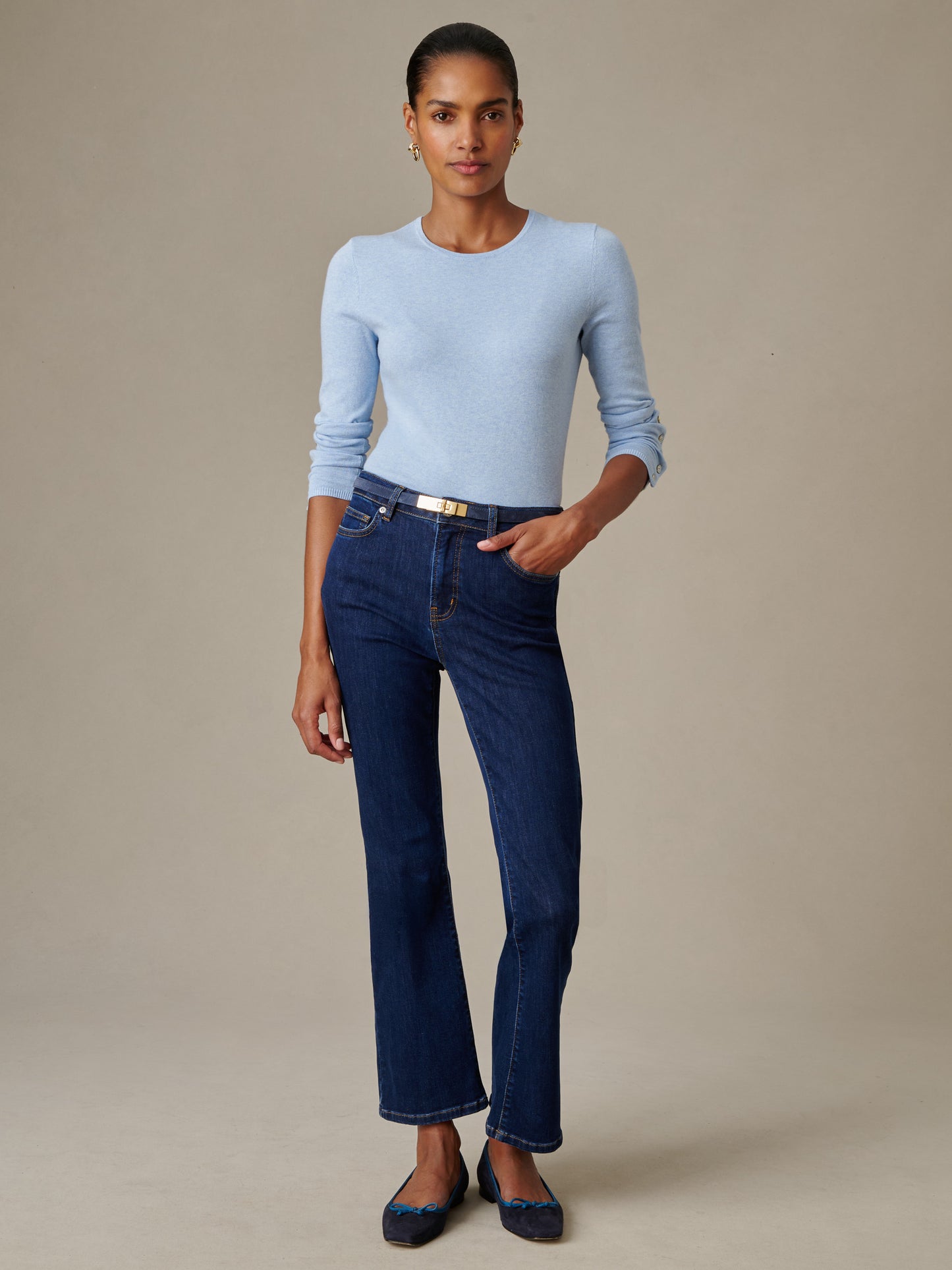 Woman wearing a light blue Jamey Sweater paired with dark blue jeans and a slim belt, showcasing J.McLaughlin’s classic, effortlessly stylish design and impeccable craftsmanship.