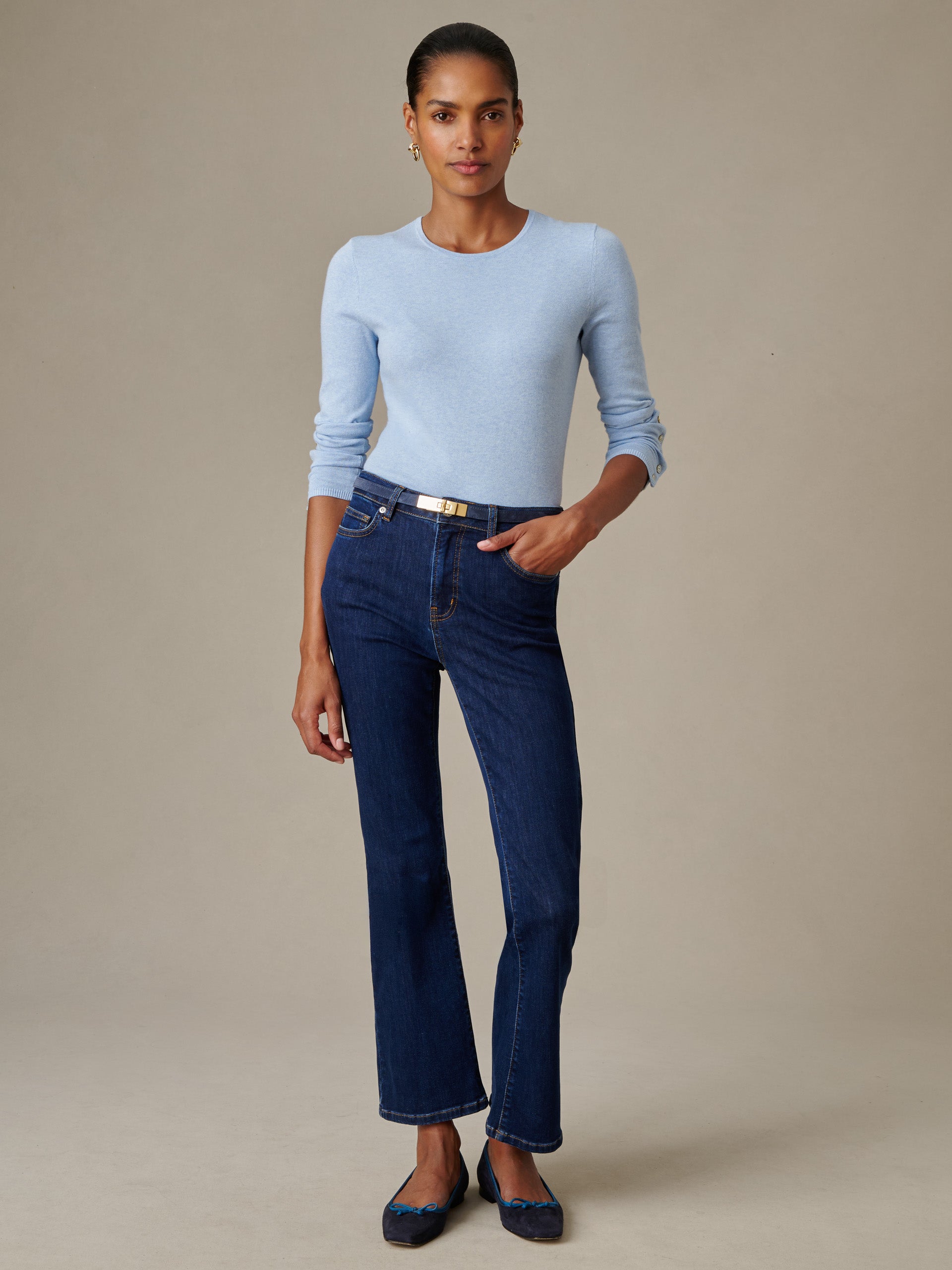 Woman wearing a light blue Jamey Sweater paired with dark blue jeans and a slim belt, showcasing J.McLaughlin’s classic, effortlessly stylish design and impeccable craftsmanship.