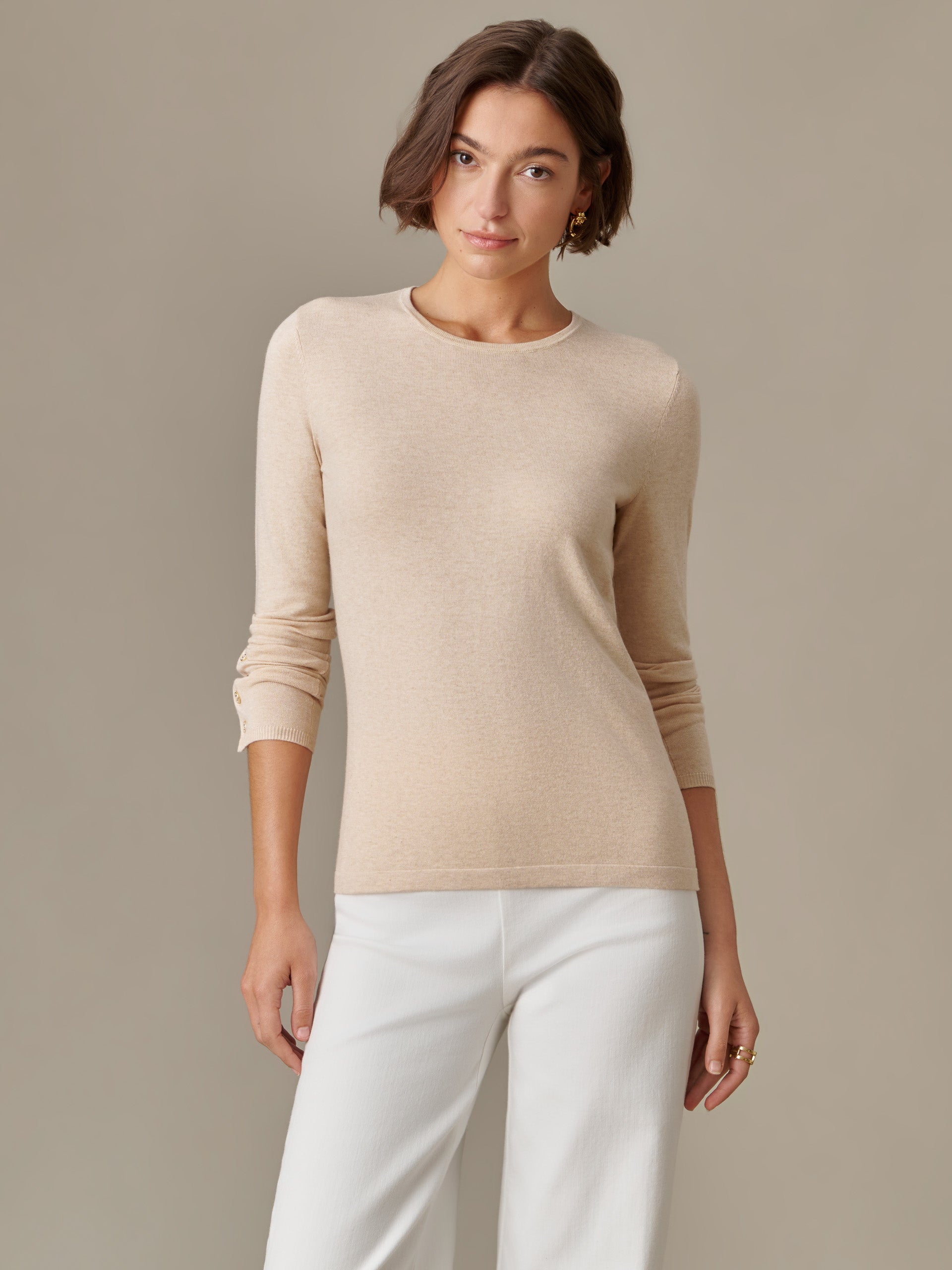 Woman wearing a beige Jamey Sweater by J.McLaughlin with long sleeves, styled simply for an effortlessly stylish and timeless look.