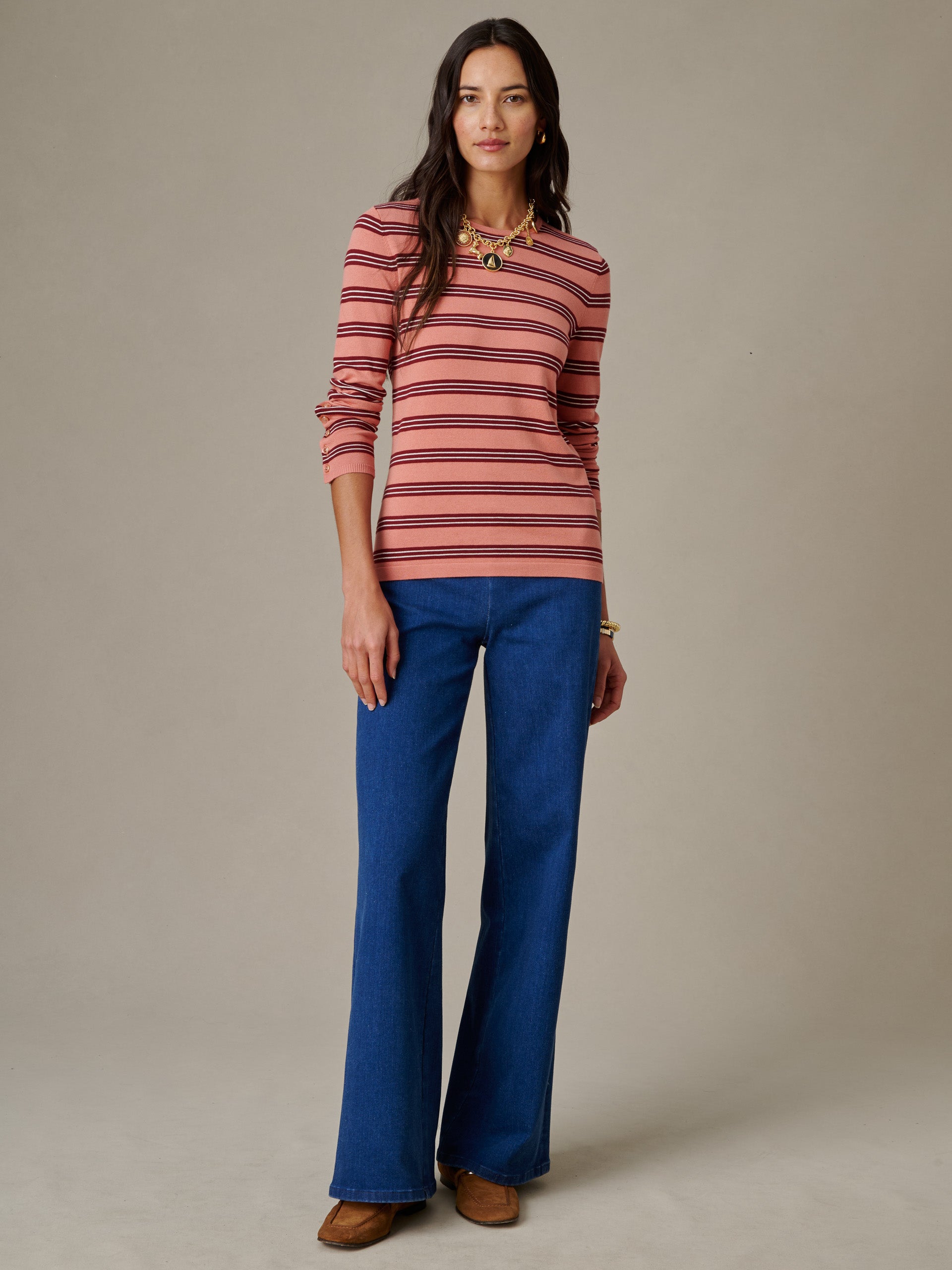 Woman wearing Jamey Sweater in Stripe by J.McLaughlin paired with blue wide-leg jeans and brown shoes, showcasing an effortlessly stylish look with enduring appeal.