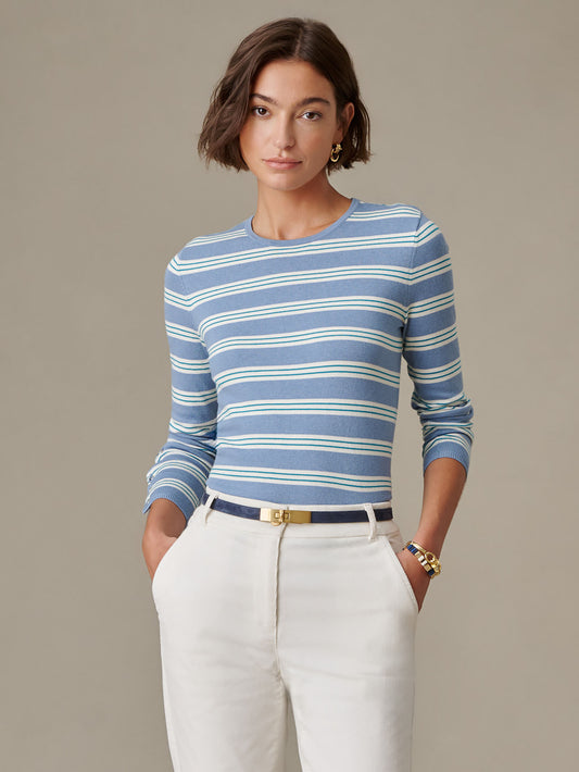 Woman wearing a blue and white striped long-sleeve sweater paired with white pants and gold accessories, showcasing the Jamey Sweater in Stripe by J.McLaughlin, a timeless and stylish choice.