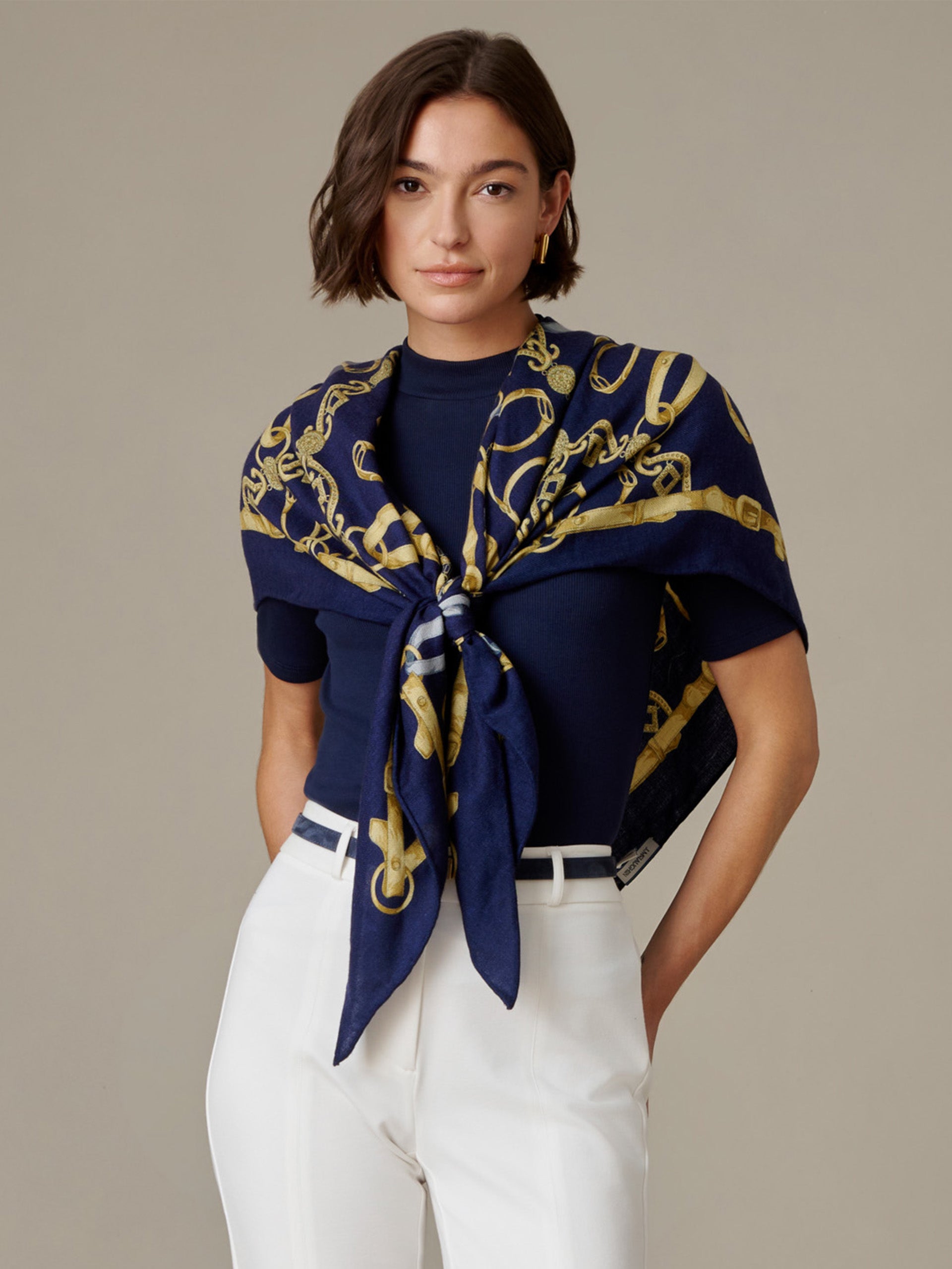 J.McLaughlin The Blair Scarf in Grand Heraldic Corner styled as a navy and gold scarf knotted over a navy top with white pants