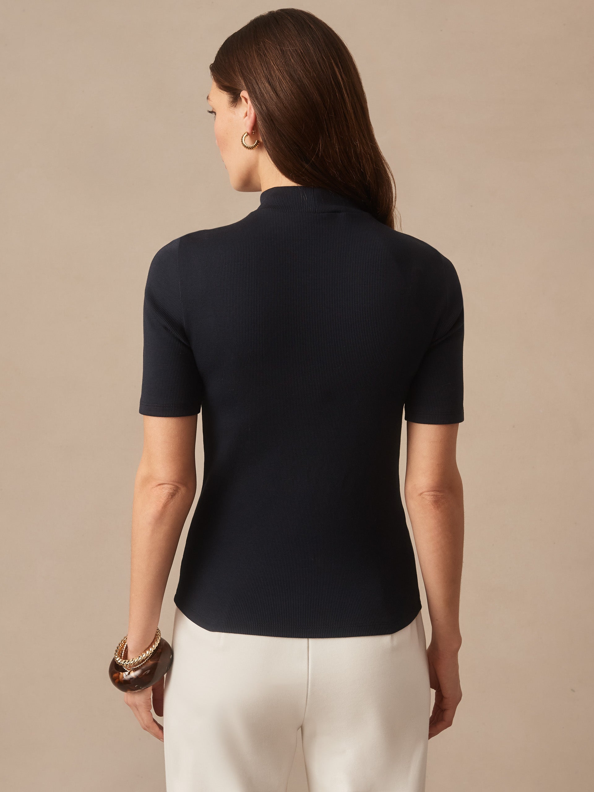 Woman wearing a navy Jess Ribbed Top by J.McLaughlin, showcasing effortlessly stylish, enduring designs crafted with innovative fabrics in a legacy of timeless fashion. A destination for defining style. Life, Well-Lived.