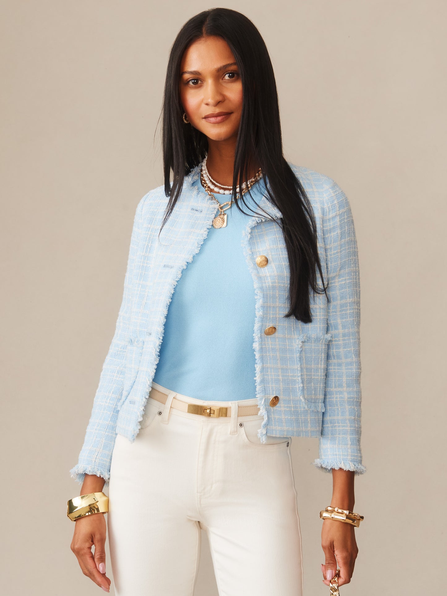 Woman wearing the Abigail Bouclé Jacket in Mini Window Pane by J.McLaughlin in a light blue textured fabric paired with a matching top, white pants, and gold accessories, showcasing effortlessly stylish, enduring designs with a legacy of timeless fashion. A destination for defining style. Life, Well-Lived.