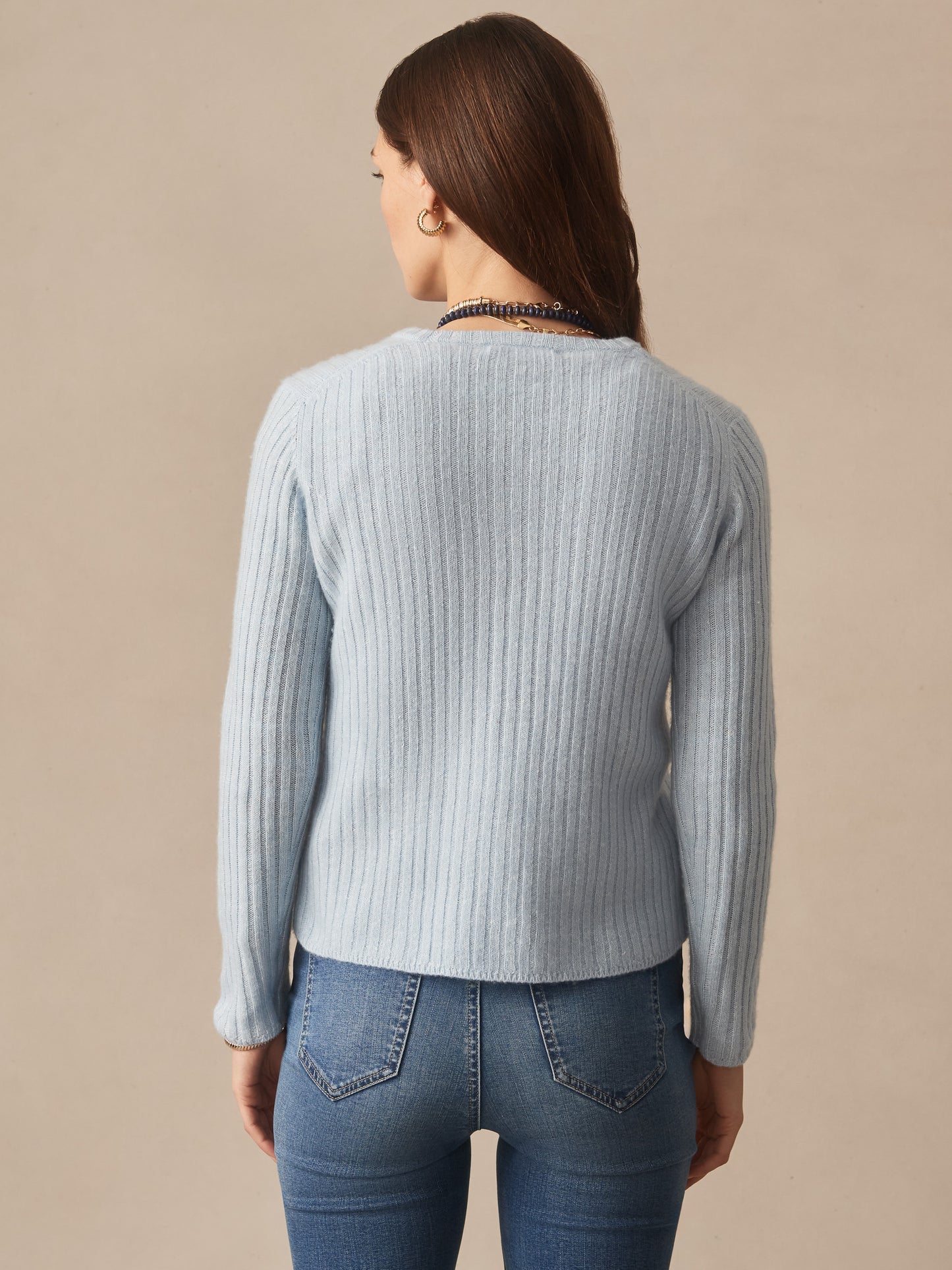 Woman modeling the Josephine Sweater by J.McLaughlin in soft blue, featuring a ribbed texture, effortlessly stylish and crafted for enduring designs with innovative fabrics.
