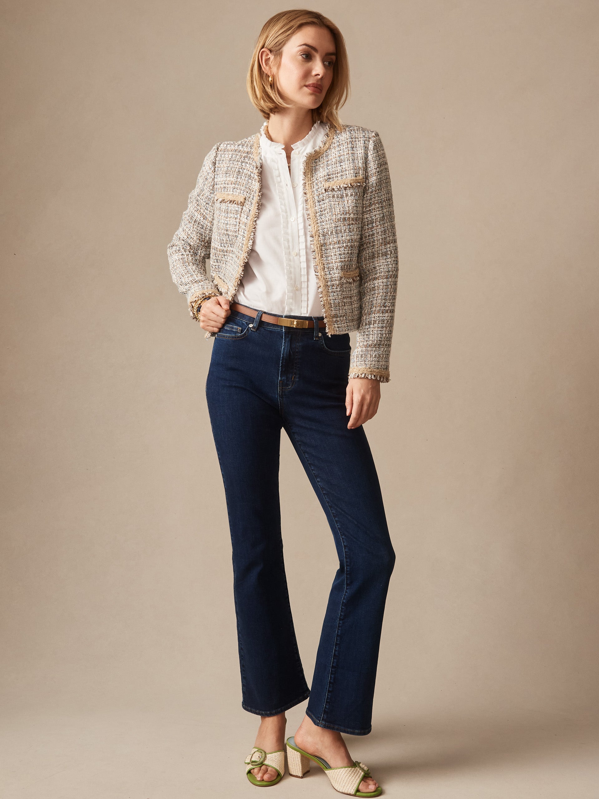 Woman wearing a Martha Tweed Jacket by J.McLaughlin over a white blouse paired with dark blue jeans and cream sandals, showcasing effortlessly stylish, enduring designs and innovative fabrics.