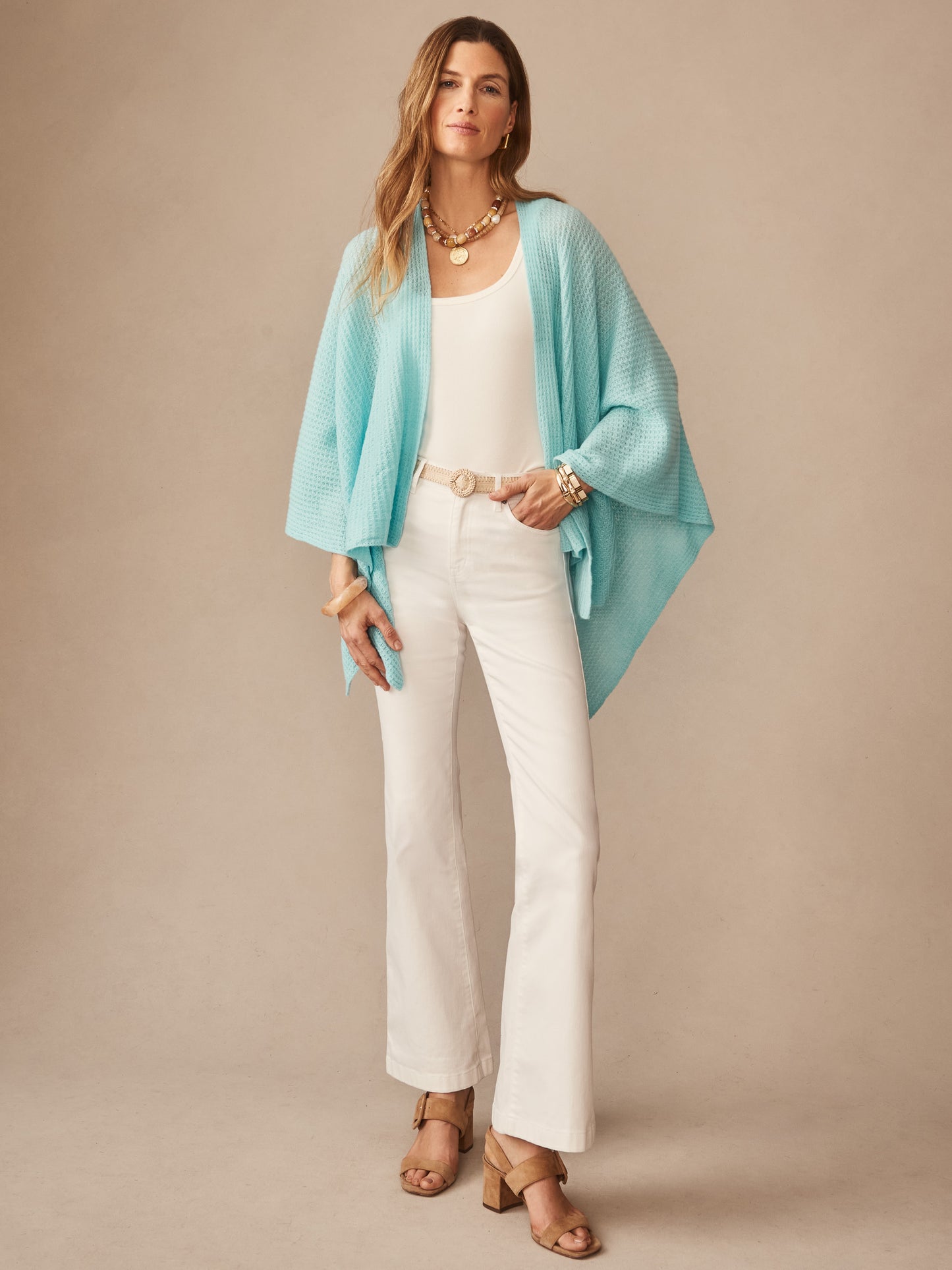 Woman wearing a seafoam Julianne Cashmere Wrap over a white top and cream pants, styled with layered necklaces and bracelets, showcasing effortlessly stylish, enduring designs by J.McLaughlin.