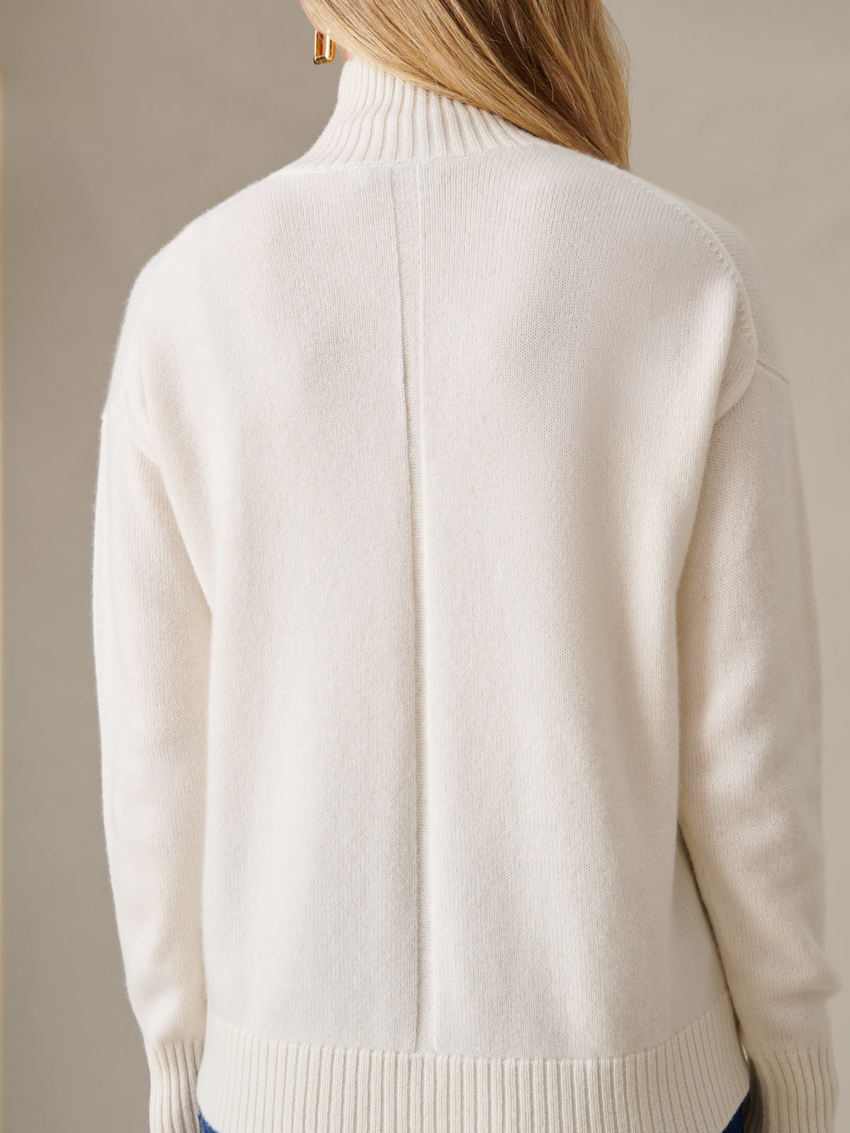 Dina Cashmere Turtleneck in soft ivory cashmere with ribbed high collar cuffs and hem shown from the back on a model