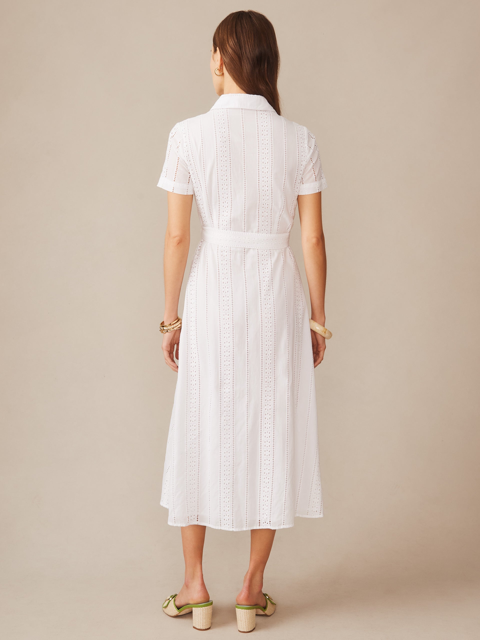 Back view of a woman wearing the Kalinda Dress in Eyelet by J.McLaughlin, featuring a white eyelet fabric with short sleeves and a classic collar, embodying effortlessly stylish, enduring designs from a destination for defining style. Life, Well-Lived.