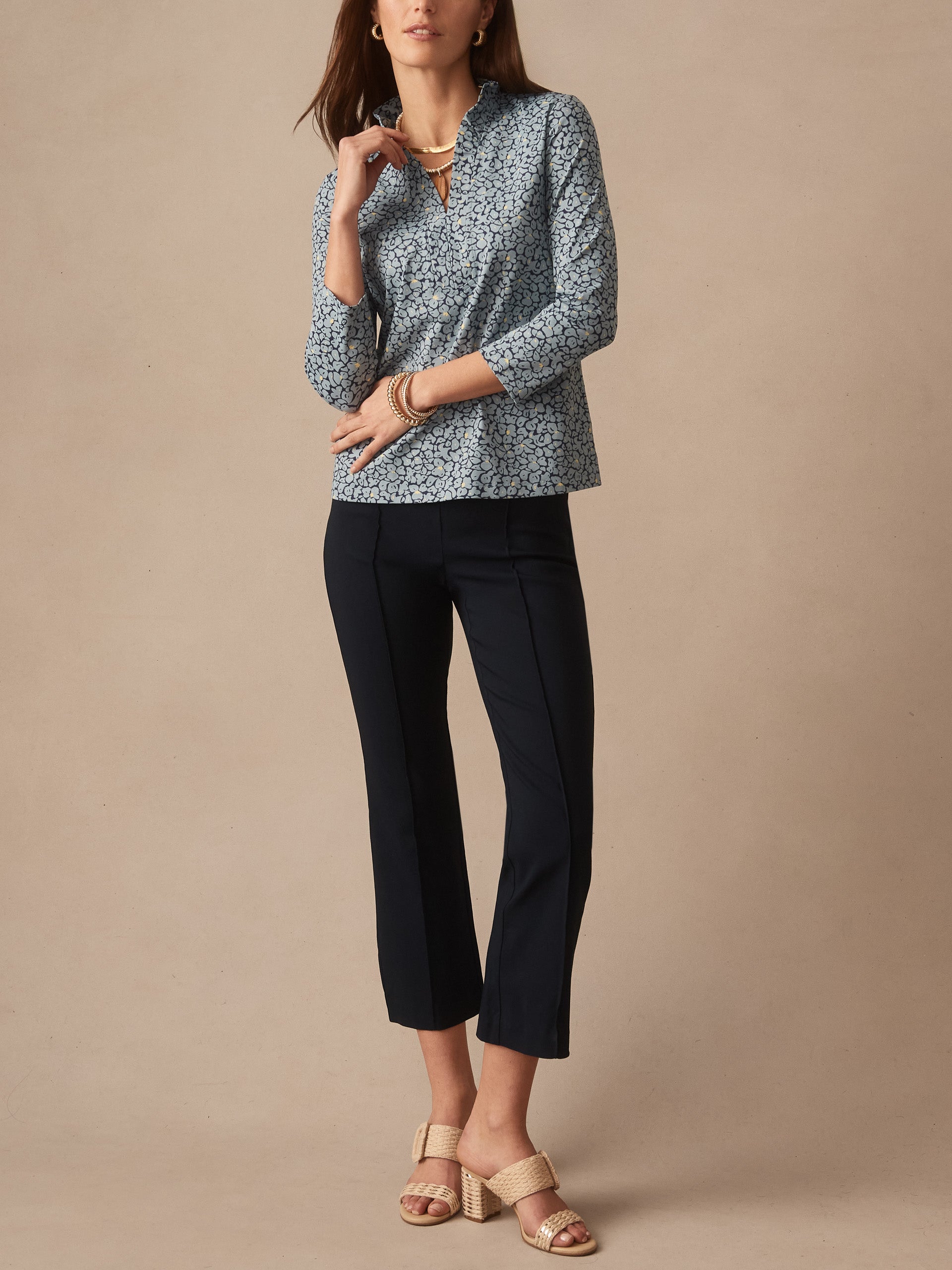 Woman modeling Kate Ruffle Top in Celandine by J.McLaughlin, featuring an effortlessly stylish floral blouse paired with tailored dark pants and woven sandals, embodying enduring designs and innovative fabrics at a destination for defining style. Life, Well-Lived.