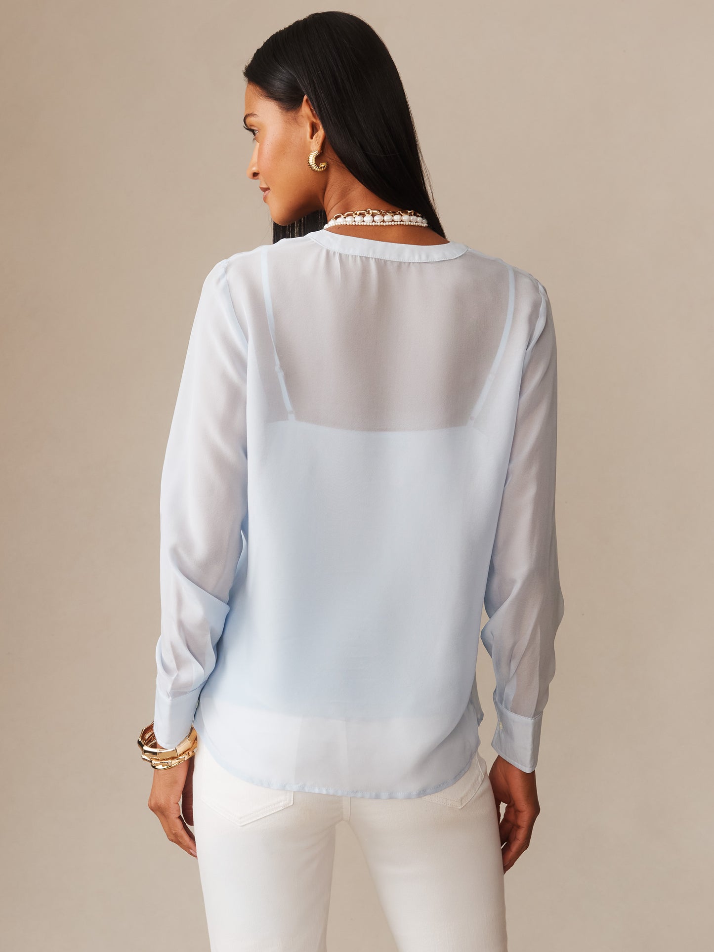 Woman wearing a light blue Katherine Silk Chiffon Blouse by J.McLaughlin, showcasing effortlessly stylish and enduring designs with innovative fabrics for a legacy of timeless fashion.