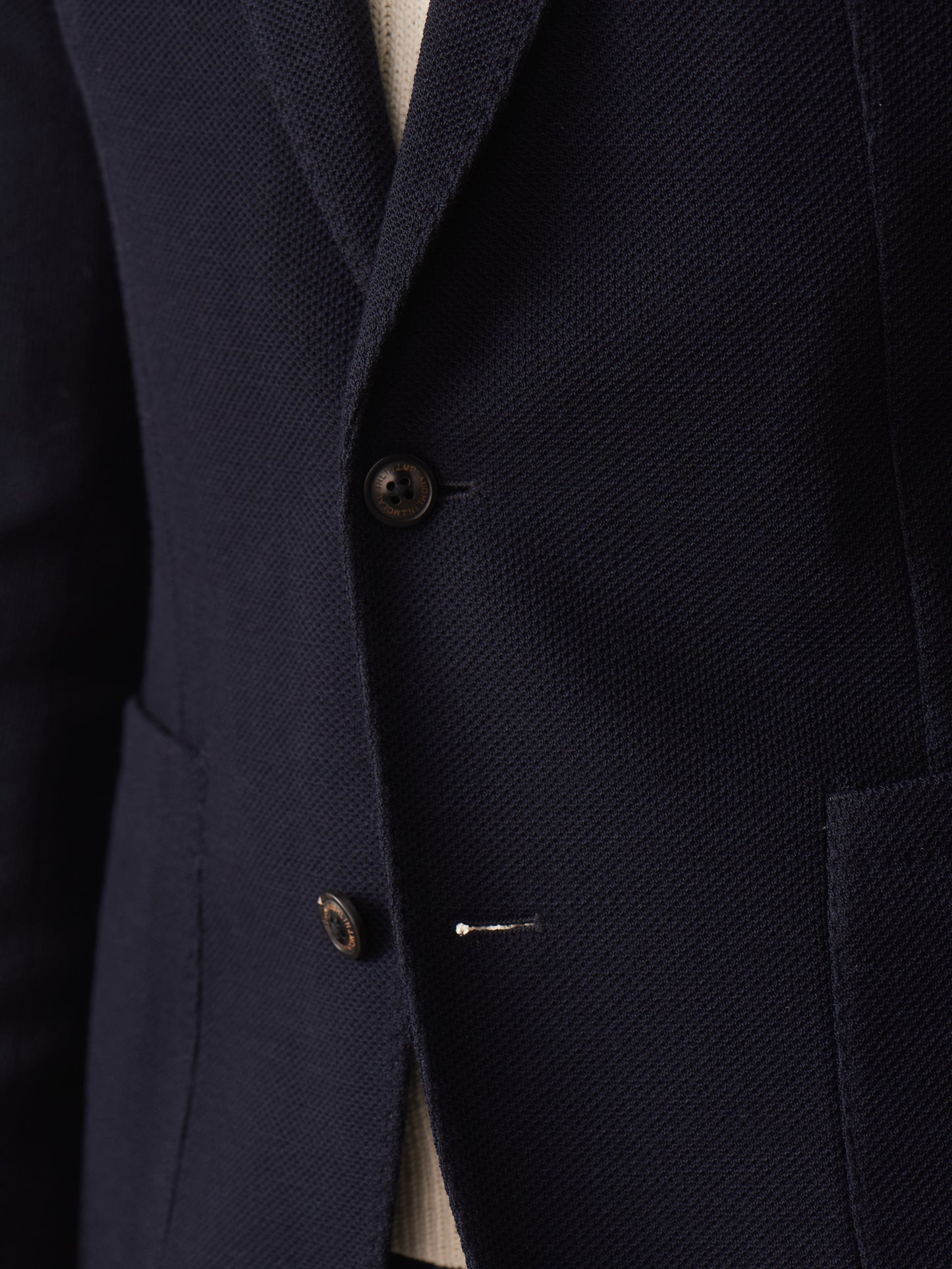 Close-up of J.McLaughlin’s Canary Knit Blazer showcasing its finely textured knit fabric and tailored buttons, reflecting effortlessly stylish, enduring designs and innovative fabrics.