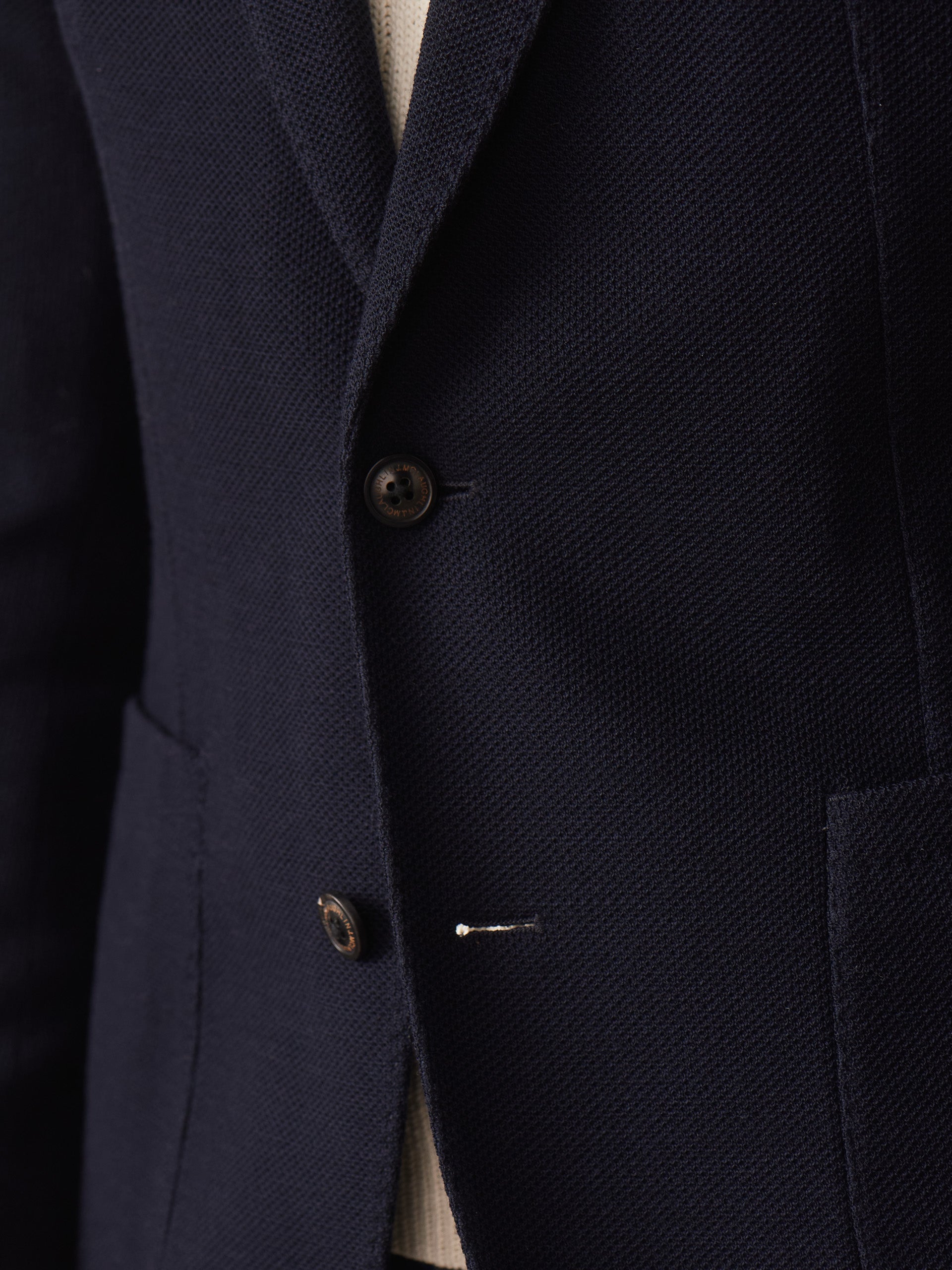 Close-up of J.McLaughlin’s Canary Knit Blazer showcasing its finely textured knit fabric and tailored buttons, reflecting effortlessly stylish, enduring designs and innovative fabrics.