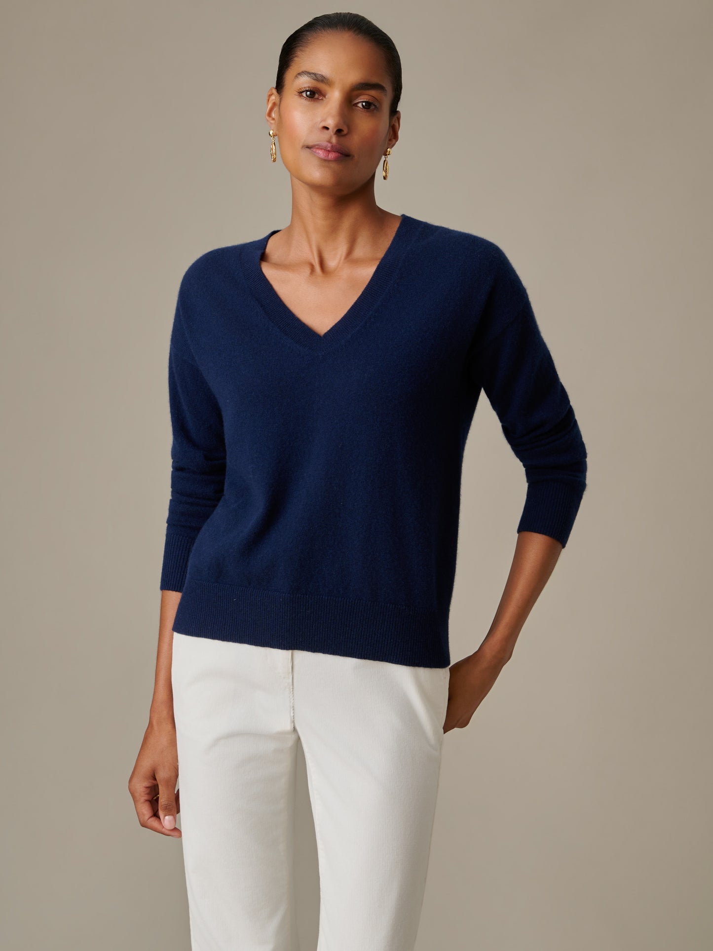 Woman wearing a navy Kerry Cashmere Sweater by J.McLaughlin paired with white pants, showcasing an effortlessly stylish and timeless classic look.