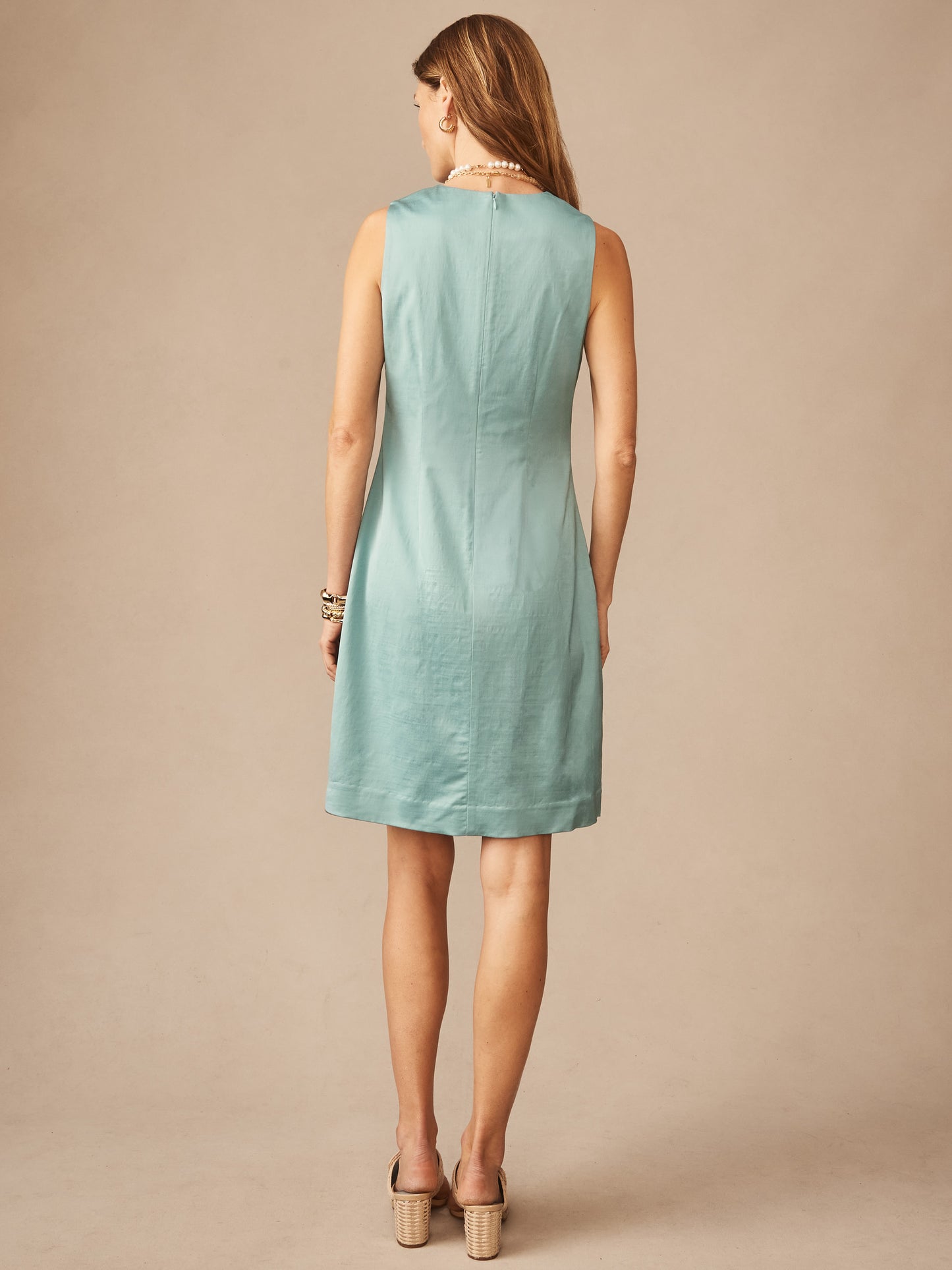 A woman models the Kinsley Dress by J.McLaughlin in a soft seafoam tone, showcasing an effortlessly stylish, enduring design crafted for a life well-lived.