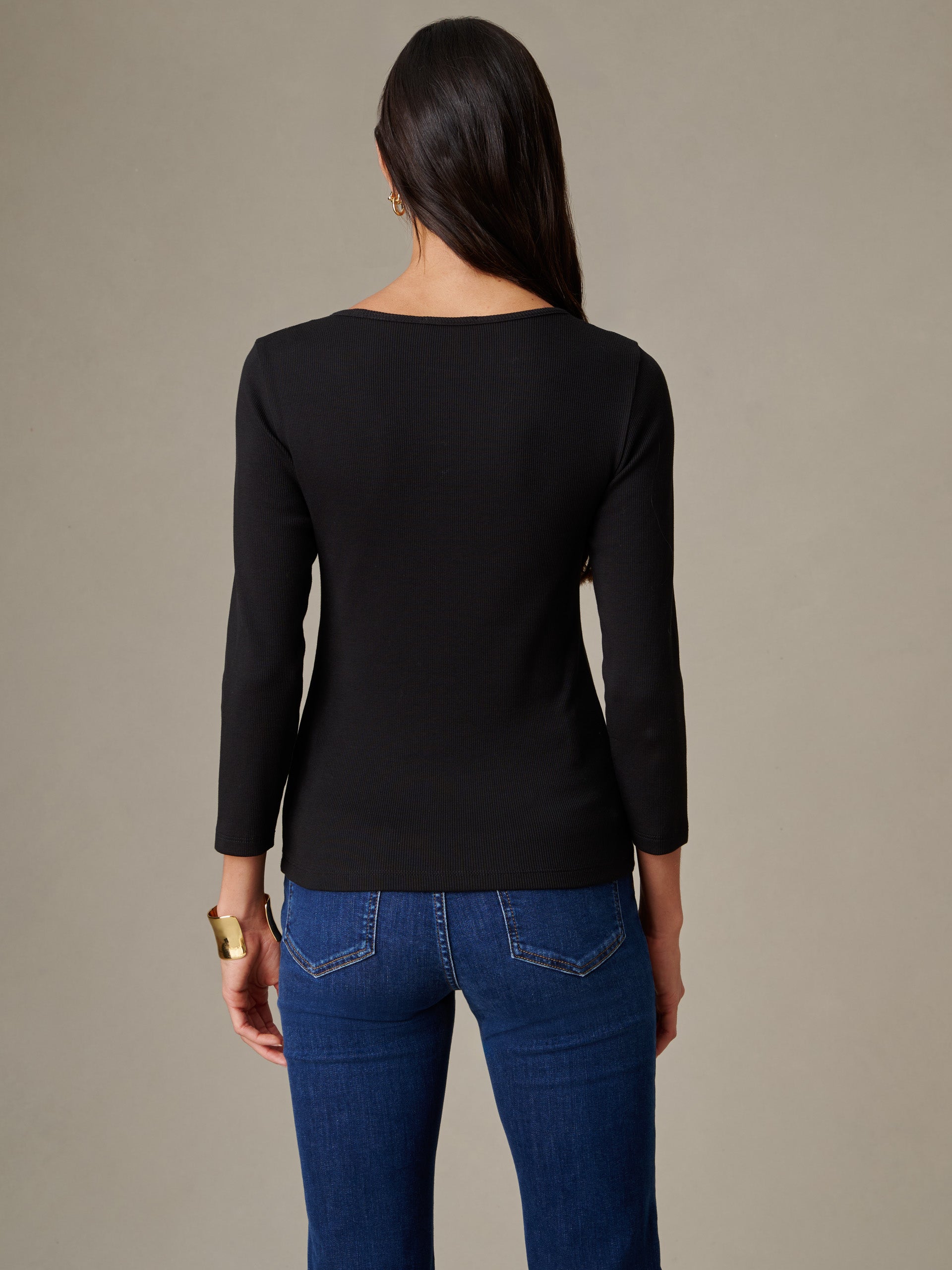 Woman seen from the back wearing a black Kit Ribbed Tee by J.McLaughlin paired with blue jeans, showcasing timeless style and impeccable craftsmanship perfect for an enduring wardrobe.