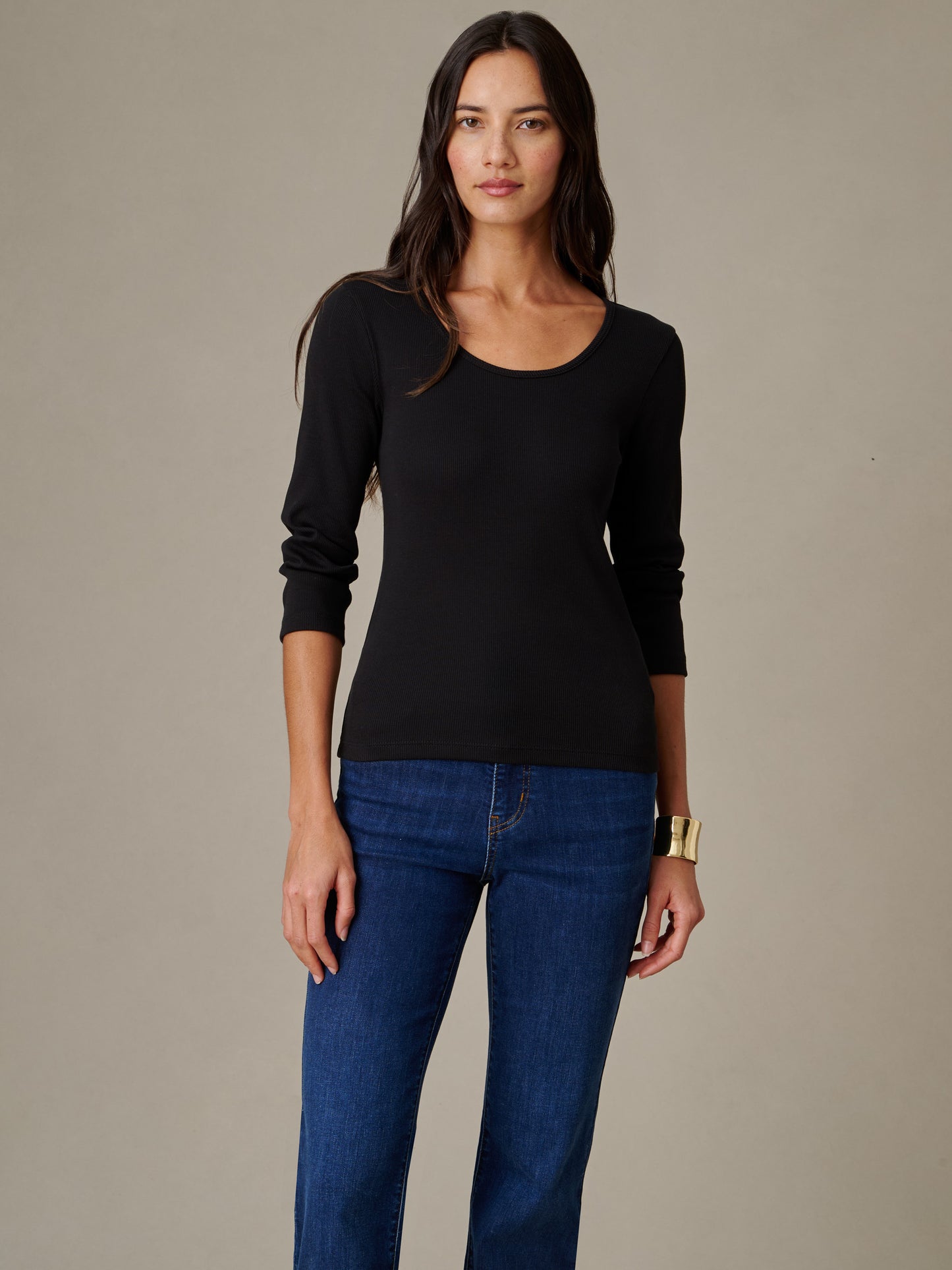 Woman modeling a black Kit Ribbed Tee by J.McLaughlin paired with blue jeans, showcasing a timeless, effortlessly stylish top with enduring design and quality craftsmanship.