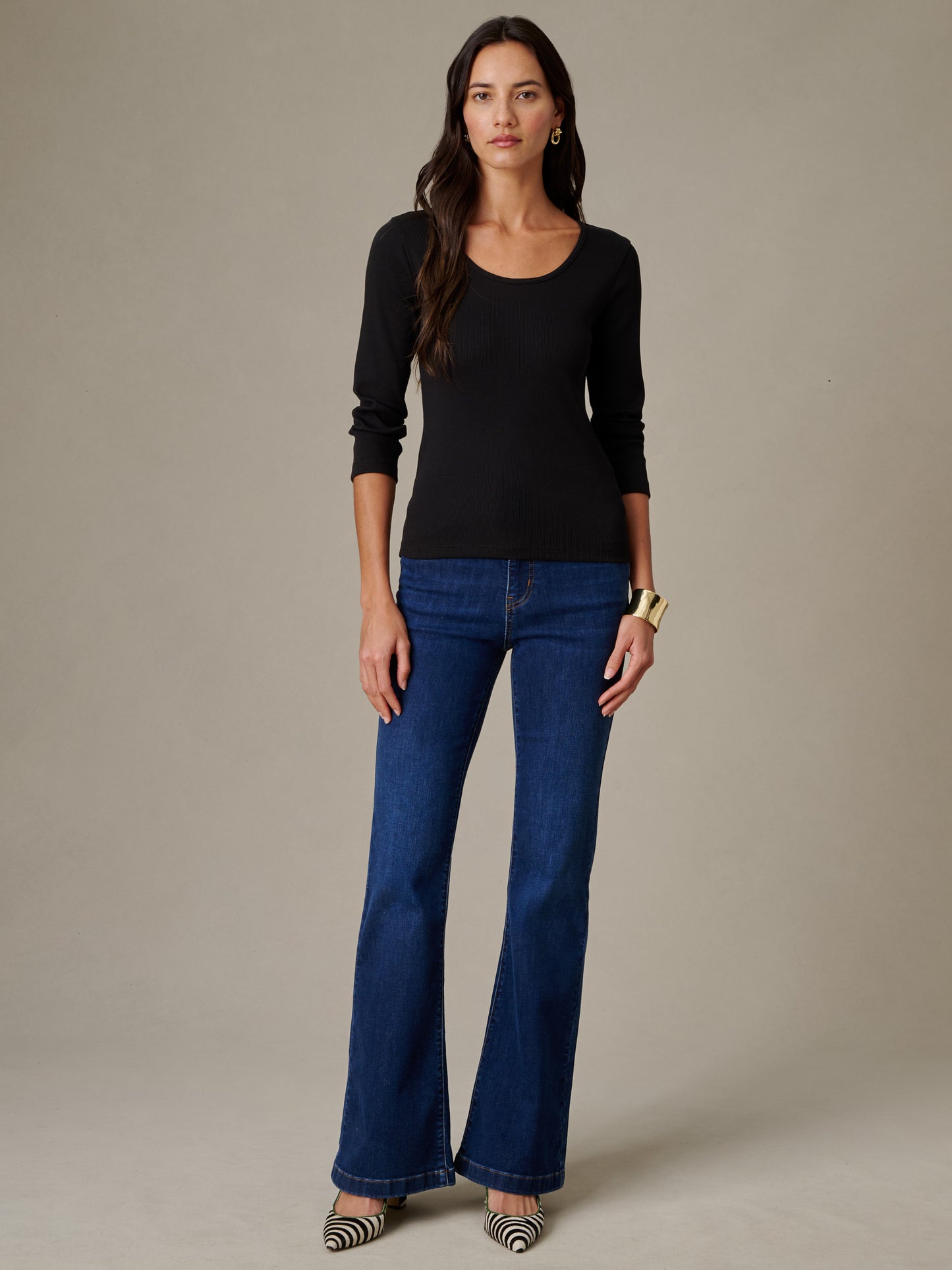 Woman wearing a Kit Ribbed Tee by J.McLaughlin paired with classic denim jeans and stylish accessories, showcasing effortlessly stylish and enduring designs.