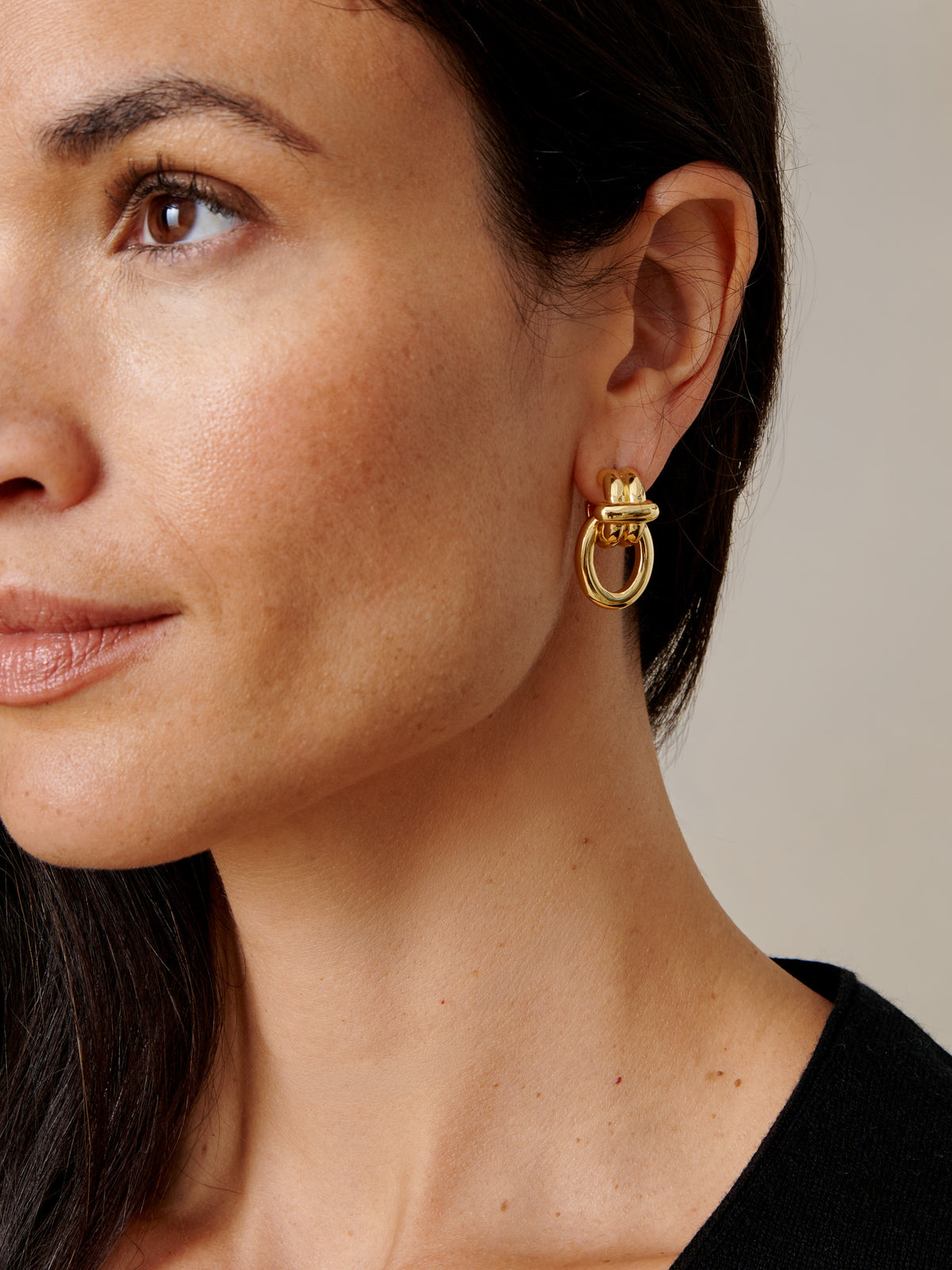 J.McLaughlin Knot Earrings in gold worn by a woman highlighting an effortlessly stylish and enduring design.