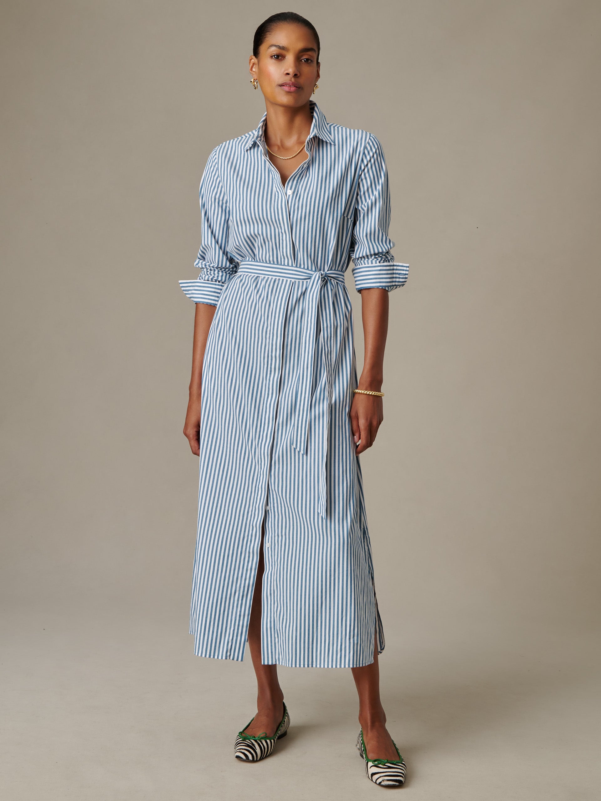 Woman wearing a J.McLaughlin Leighton Dress in Stripe, styled with rolled sleeves and a waist tie, showcasing an effortlessly stylish, timeless design perfect for enduring appeal.